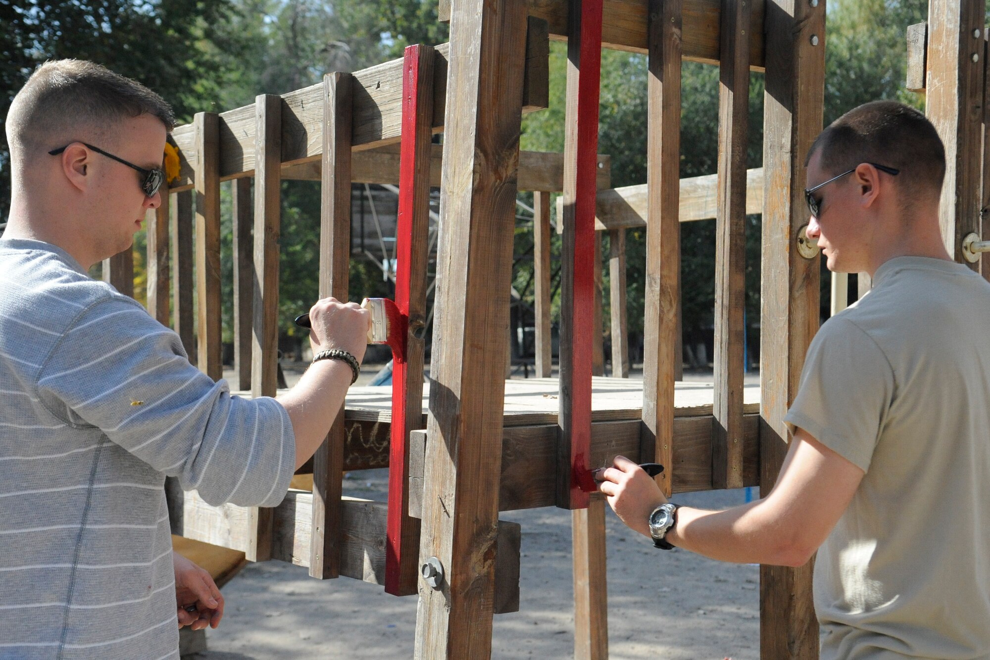 Airman 1st Class Joshua Spencer (left) and 2nd Lt. Tristan Mountsier paint playground equipment at the Nizhanchuisk Orphanage and School, Kyrgyzstan, Oct. 13. The Airmen are both members of the Manas Area Benefit Outreach Society, a private organization established in 2003 as a means for Airmen deployed to the Tranist Center at Manas to aid organizations in the surrounding area. Spencer is a 376th Expeditionary Security Forces Squadron patrolman deployed from MacDill Air Force Base, Fla. Mountsier is a 376th ESFS Bravo Flight commander deployed from Little Rock AFB, Ark. (U.S. Air Force photo/Tech. Sgt. Tammie Moore)