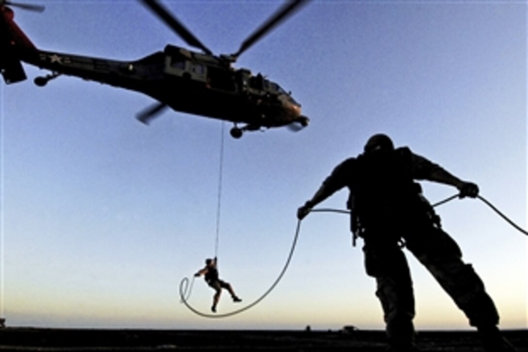 A U.S. sailor rappels from an MH-60S Sea Hawk helicopter during a training exercise aboard the USS Gettysburg in the Arabian Sea, Oct. 6, 2011. The sailor is assigned to Explosive Ordnance Disposal Mobile Unit 2. The Gettysburg is deployed to the U.S. 5th Fleet area of responsibility conducting maritime security operations and support missions as part of operations Enduring Freedom and New Dawn.