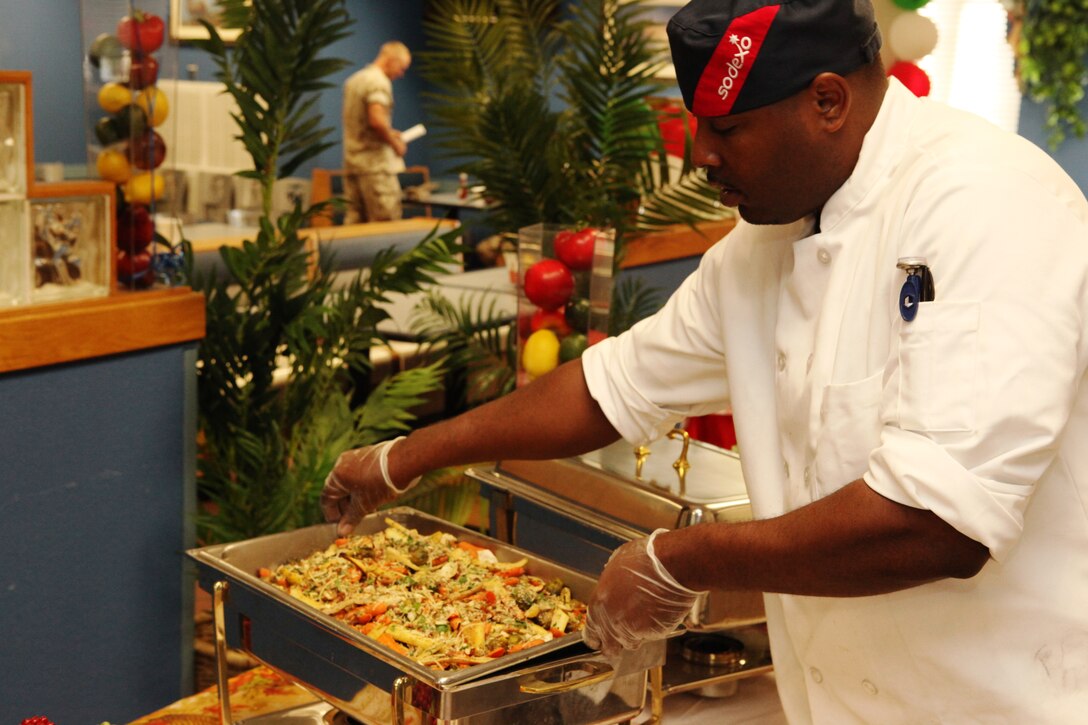 A civilian chef sets up his table for presentation to guests and judges during the third quarter Culinary Team of the Quarter competition at Mess Hall 411 abaord Marine Corps Base Camp Lejeune, Oct. 18.