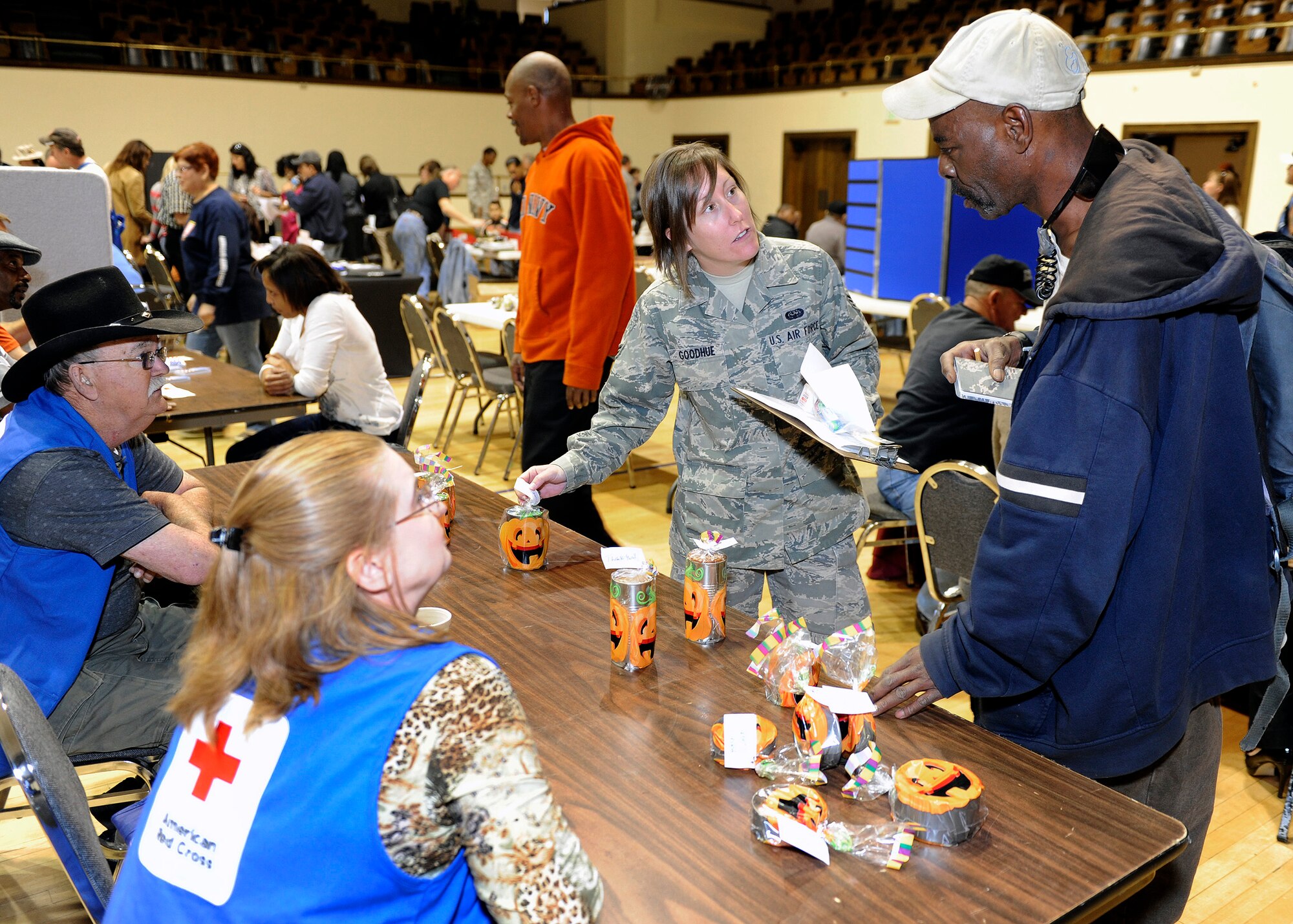 Senior Airman Lauren Goodhue from the 50th Space Communications Squadron escorts John Brame through various stations at the 13th annual Vetrans Stand Down. The event drew more than 120 homeless or impoverished veterans to the City Auditorium downtown. This event connected them with the federal services they are eligible to receive and provided them with much needed clothing and a hot meal. (U.S. Air Force Photo/David Ahlschwede

