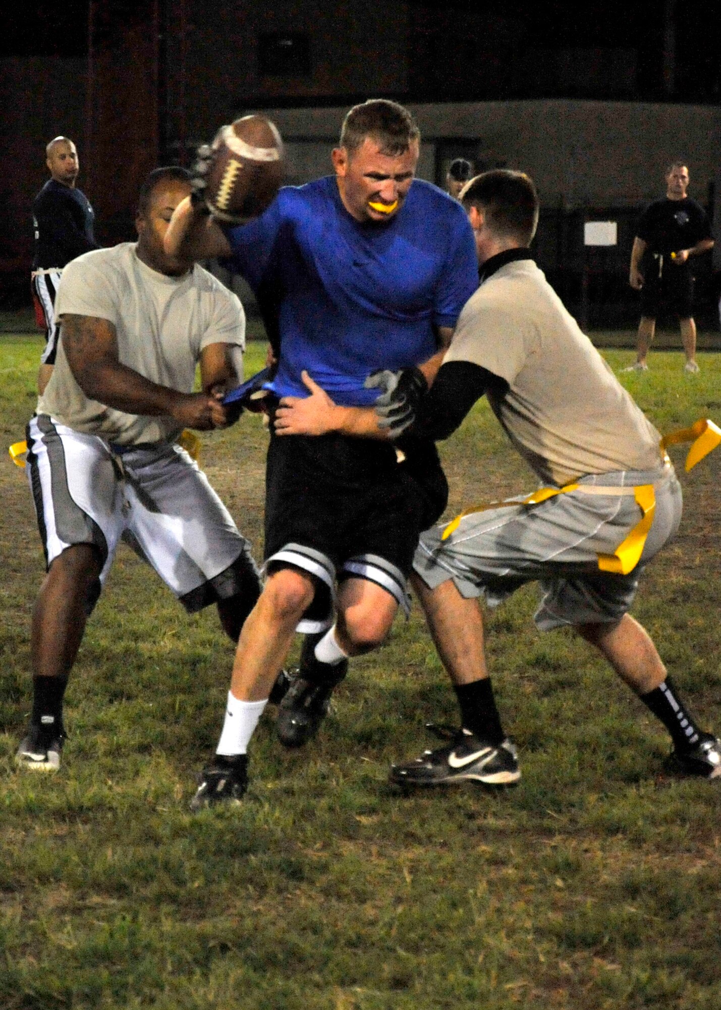 Patrick Ogborn, of the 436th Civil Engineer Squadron B team, attempts to evade two 436th Force Support Squadron/Comptroller Squadron defenders during an American League flag-football game on Oct. 17, 2011 at Dover Air Force Base, Del. The game ended in a 20-20 tie. (U.S. Air Force photo by Tech. Sgt. Chuck Walker)