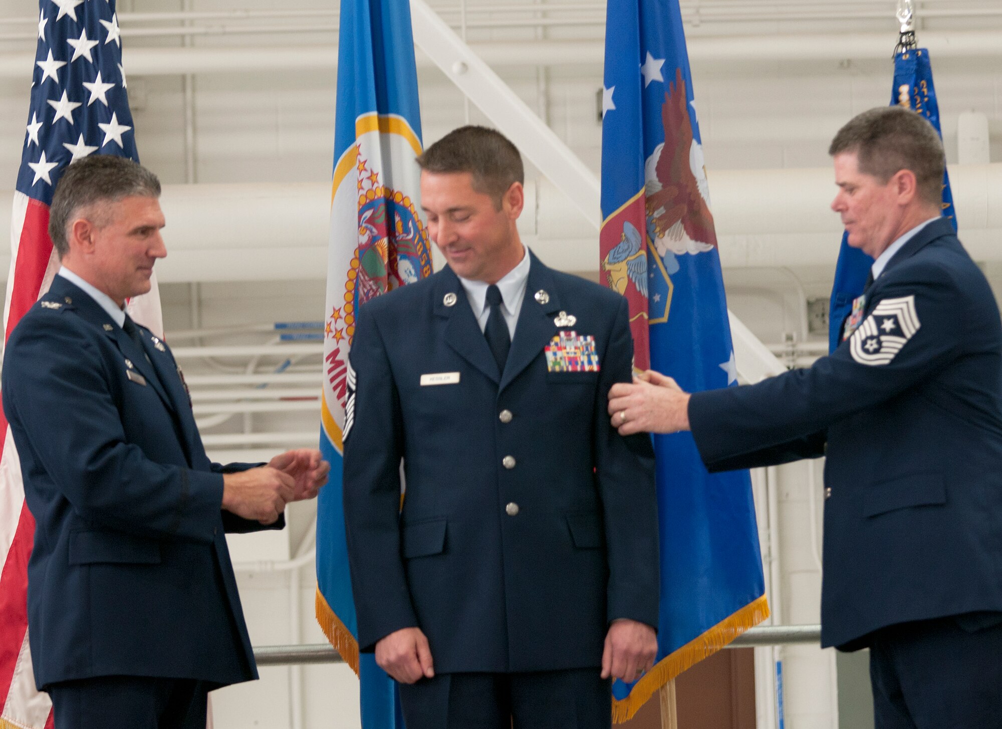 Chief Master Sgt. Paul Kessler (center), 133rd Communications Flight, becomes the Command Chief of the 133rd Airlift Wing, Minnesota Air National Guard, during a change of authority ceremony at the Air Guard base in St. Paul, Minn. on Oct. 15, 2011. He was selected by Col. Greg Haase (left), 133rd AW commander, to replace Chief Master Sgt. David Speich, 133rd Civil Engineer Squadron, who has served as the top enlisted member of the Wing for the past three and a half years. Minnesota Air National Guard Command Chief, Chief Master Sgt. Greg Close (right) assists by helping the commander reveal the star in the chevron, symbolizing the authority the new command chief holds as he serves the Airmen of the 133rd AW. USAF official photo by Tech. Sgt. Erik Gudmundson