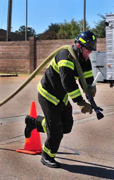 U.S. Air Force Senior Airman Cody Nelson, 20th Civil Engineer Squadron firefighter apprentice, drags a fire hose during a practice run for the Scott Firefighter Combat Challenge national relay in support of Fire Prevention Week at the Shaw Air Force Base Fire House, S.C. Oct. 14, 2011. The fire department held an open house for the Shaw community to learn about fire safety tips and prevention. Firefighters put on several demonstrations during the open house. (U.S. Air Force photo by Airman 1st Class Amber E. N. Jacobs/Released)