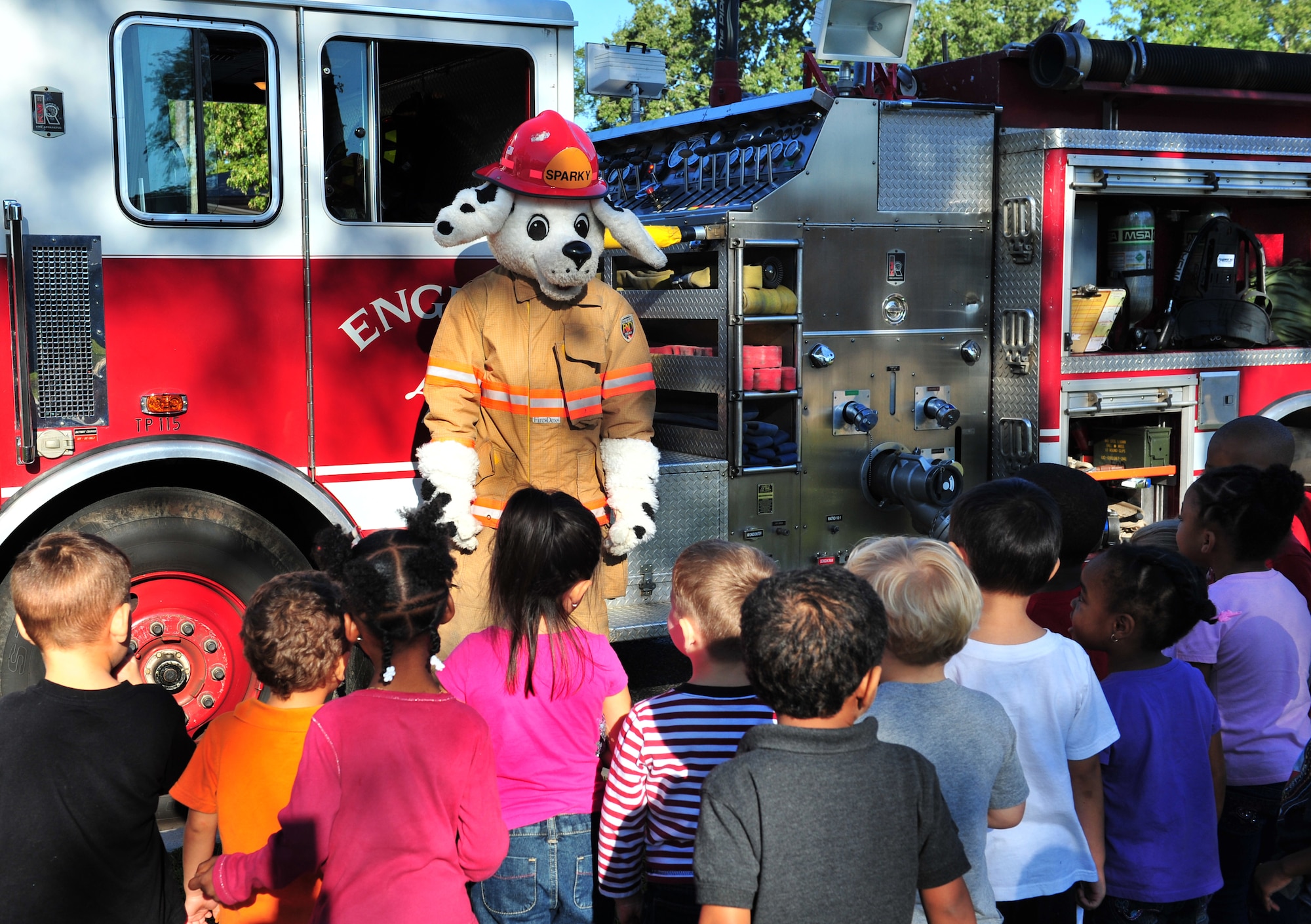 Sparky the Fire Dog shows children a fire engine at the Child Development Center in support of Fire Prevention Week at Shaw Air Force Base, S.C. Oct. 14, 2011. Sparky visited with the children to emphasize the importance of fire safety and to familiarize the young kids with the fire department. (U.S. Air Force photo by Airman 1st Class Amber E. N. Jacobs/Released)