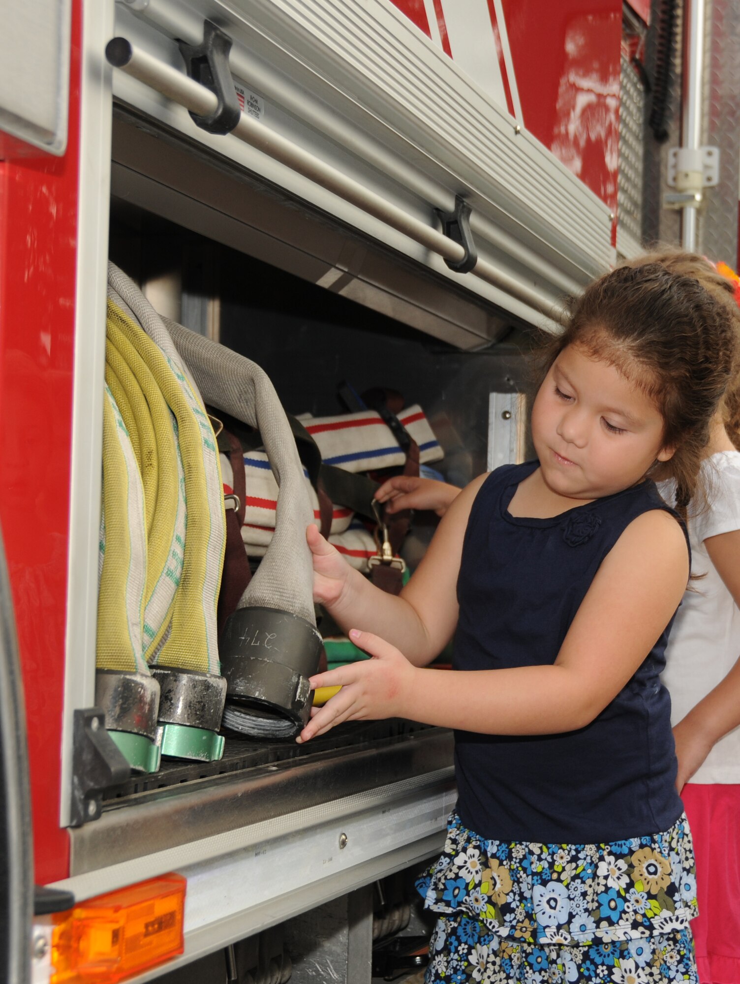 Laylah Sadler, 4, daughter of Senior Airman Jeffrey and Lytha Sadler, 81st Logistics Readiness Squadron, receives a hands-on experience with items on a fire truck including fire hoses during a visit from Keesler Fire Department members Oct. 12, 2011, at Keesler Air Force Base, Miss.  Fire Prevention week was held Oct. 11-15.  Sadler is currently deployed to Iraq.  (U.S. Air Force photo by Kemberly Groue)