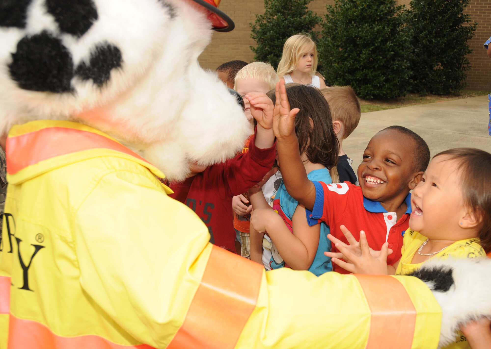Sparky the fire dog is greeted by Nigel Pittman, 3, Vivian Nguyen, 3, and other children at the Child Development Center Oct. 12, 2011, at Keesler Air Force Base, Miss.  Nigel is the son of Senior Airman Shacoya Pittman, 81st Logistics Readiness Squadron.  Vivian is the daughter of Staff Sgt. Samuel Nguyen, 81st Training Support Squadron and Kienminh Bui.  Fire Prevention week was held Oct. 11-15.  (U.S. Air Force photo by Kemberly Groue)