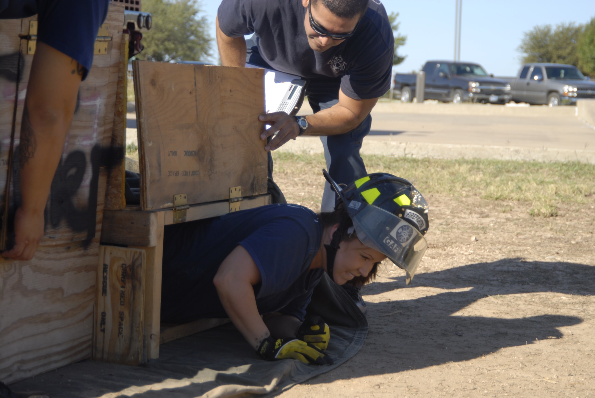 GOODFELLOW AIR FORCE BASE, Texas – Stephanie Kammer, spouse of a Goodfellow firefighter, works her way out of a confined space obstacle during a firefighter competition muster here Oct. 14. The fire department hosted the competition as part of the 89th National Fire Prevention Week, and to help raise awareness of fire safety. (U.S. Air Force photo /Senior Airman Heather L. Rodgers)