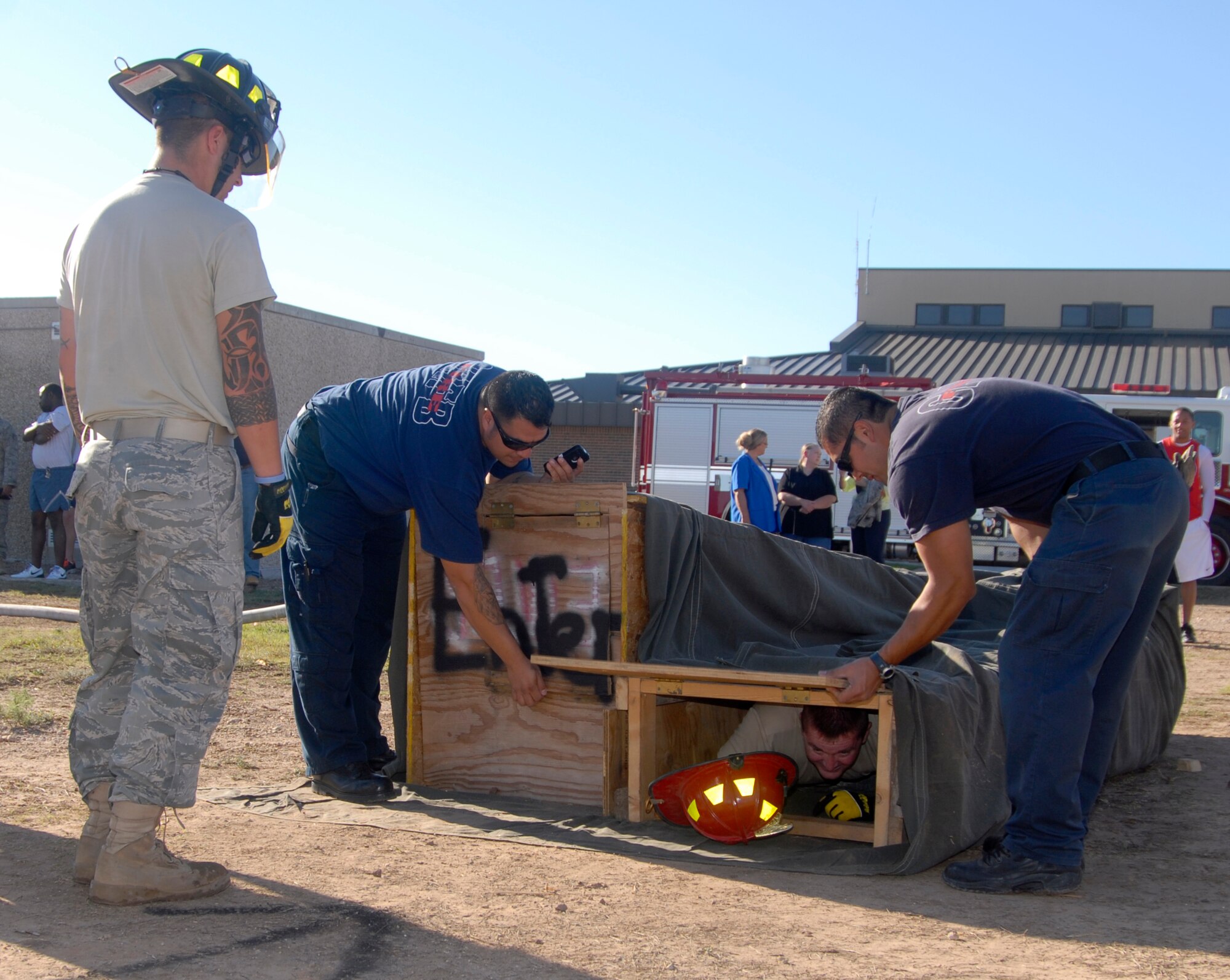 GOODFELLOW AIR FORCE BASE, Texas – Maj. Dennis Turriff, 17th Security Forces Squadron Commander, works his way through a confined space obstacle during a firefighter competition muster here Oct. 14. The fire department hosted the competition as part of the 89th National Fire Prevention Week, and to help raise awareness of fire safety. (U.S. Air Force photo /Senior Airman Heather L. Rodgers)