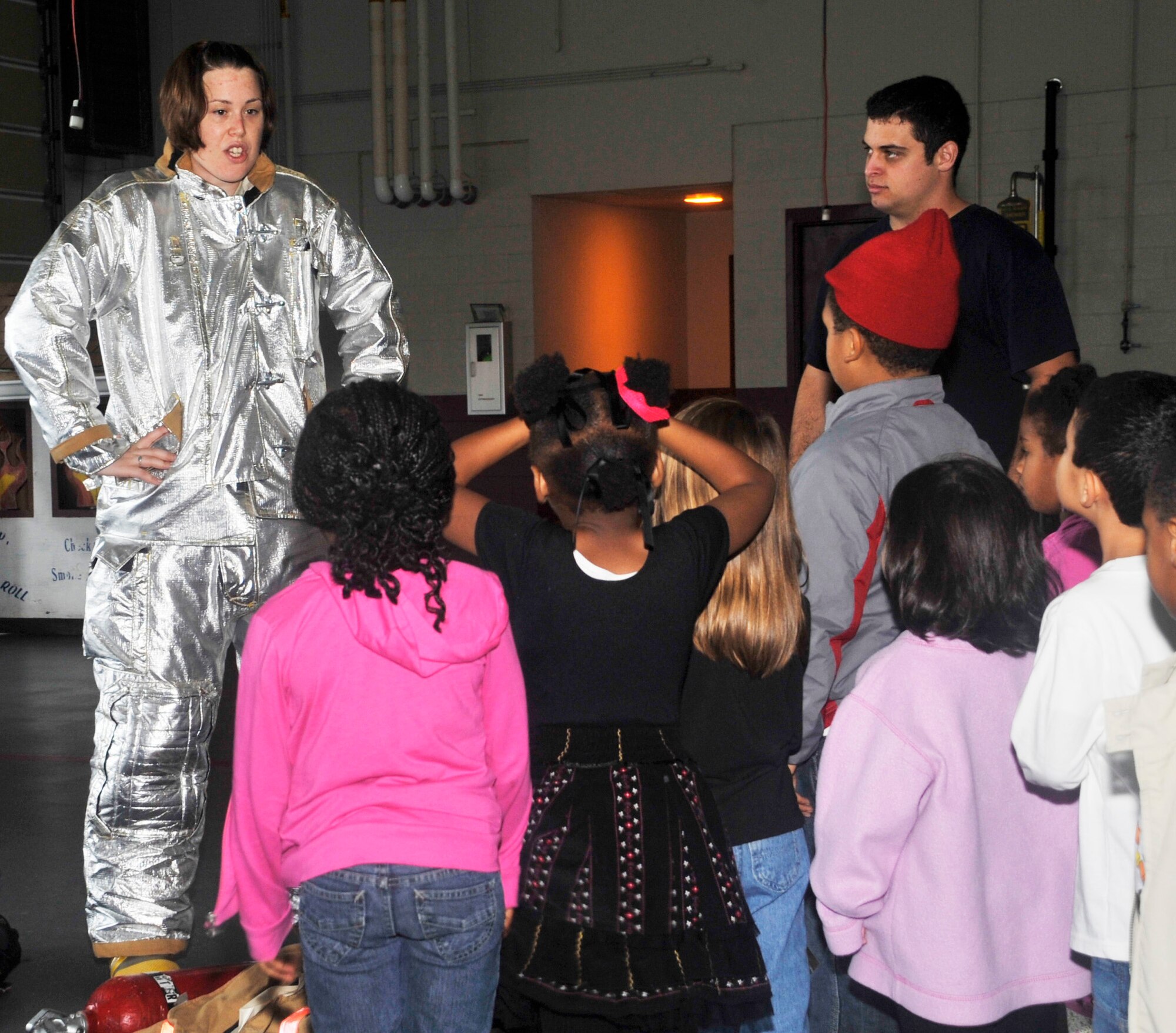 Staff Sgt. Darliska Blessing demonstrates firefighter-protective gear Oct. 13, 2011, to children from the Dover Air Force Base, Del., Child Development Center. The demonstration's goal was to help educate children on what a firefighter looks like and to alleviate the fear of a firefighter in full gear. (U.S. Air Force photo by Tech. Sgt. Charles Walker)