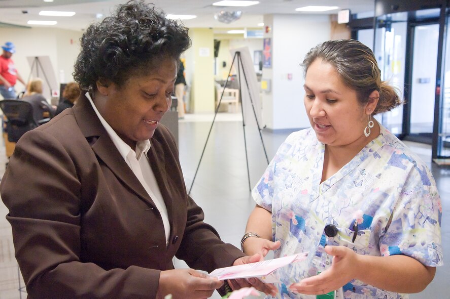 Jessica Leon, a technician at the Women’s Health Clinic with the 436th Medical Group, shows Denise Hardy, a registered nurse, a pamphlet about breast cancer at the Breast Cancer Awareness and Education Booth Oct. 12, 2011, at Dover Air Force Base, Del. The booth educated Team Dover members about breast cancer and breast health in recognition of Breast Cancer Awareness Month. (U.S. Air Force photo by Adrian Rowan)