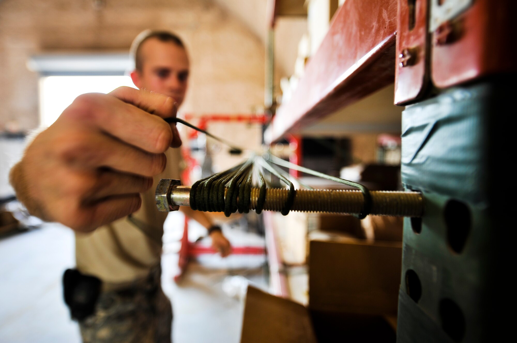 Sgt. Michael Gray, 824th Quartermaster Company Det. 10 lane chief, wraps 550 cord or parachute cord around a bolt to measure the length Oct. 14, 2011, at an undisclosed location in Southwest Asia. Gray, a native of Killeen, Texas, is deployed from the U.S. Army Reserve's 861st Quartermaster Company in Nashville, Tenn. (U.S. Air Force photo/Senior Airman Paul Labbe) 