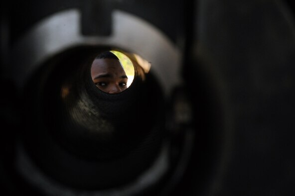 Senior Airman Billy Reams,1st Special Operations Equipment Maintenance Squadron, looks down the barrel of a 105mm gun on an AC-130 during the Fall Festival at the Freedom Hangar, Hurlburt Field, Fla., Oct. 15, 2011. Attendees of the festival were allowed full access to the aircraft. (U.S. Air Force photo/Senior Airman Eboni Reams)