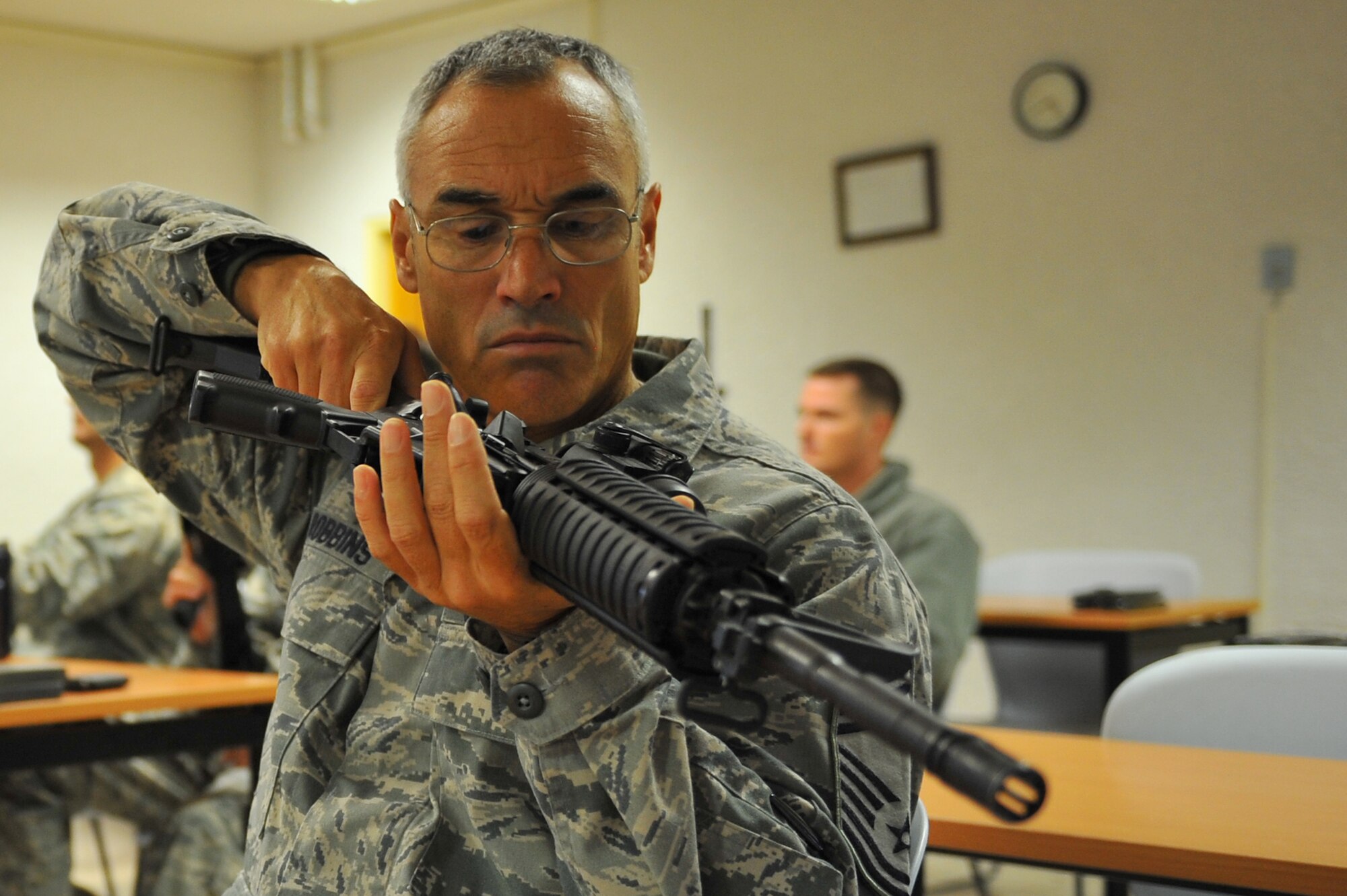 SPANGDAHLEM AIR BASE, Germany – Chief Master Sgt. Scott Robbins, 606th Air Control Squadron chief enlisted manager, observes the chamber of an M-4 assault rifle during the new weapons training and qualifications class here Oct. 13. Air Force leadership modernized the rifle qualification course by adding movement while engaging targets to better train and equip Airmen for today’s fight. Spangdahlem AB is the first base in United States Air Forces in Europe to initiate the new qualification course. (U.S. Air Force photo/Airman 1st Class Dillon Davis)