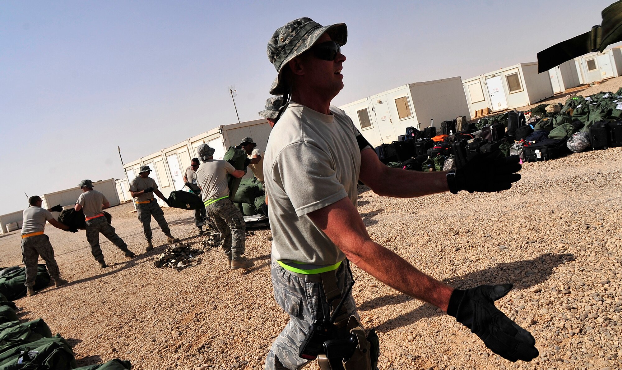 Senior Master Sgt. Frank Dewan, 125th Expeditionary Fighter Squadron propulsion shop chief, tosses a bag to a co-worker during in-processing at their base in Iraq Oct. 1, 2011. The squadron deployed in support of Operation New Dawn and will provide close air support for more than 40,000 troops leaving Iraq by the end of the year. The 125th EFS comprises F-16 Fighting Falcons, pilots, maintenance specialists and support personnel from the Oklahoma Air National Guard's 138th Fighter Wing in Tulsa, Okla., and the Ohio Air National Guard's 180th Fighter Wing in Toledo, Ohio. (U.S. Air Force photo/Master Sgt. Cecilio Ricardo)