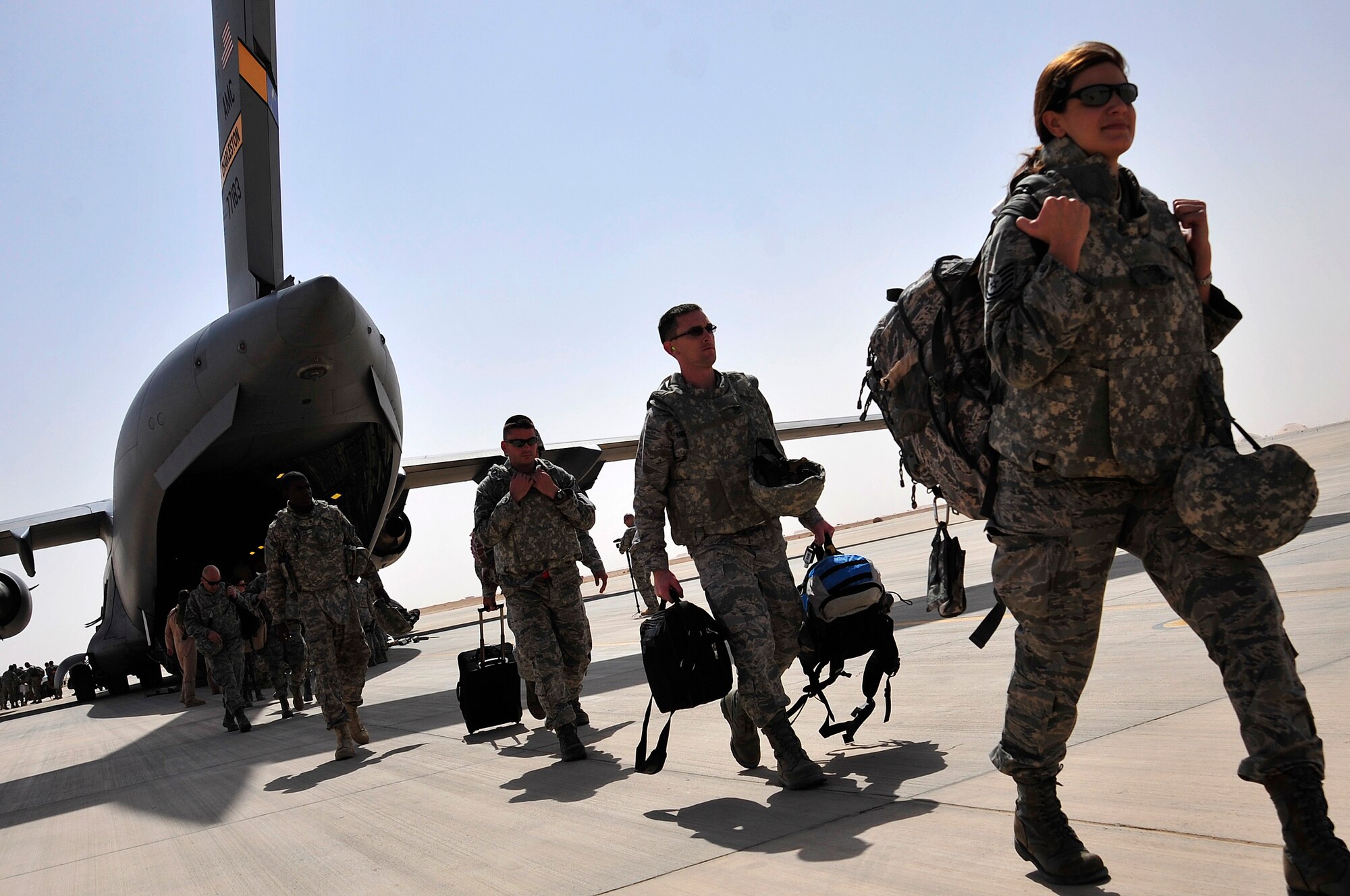 Staff Sgt. Valerie Fleming, right, ordnance systems mechanic, 1st Lt. Joseph Baszynski, aircraft maintenance unit officer-in-charge, Master Sgt. Derek Harry, quality assurance, and other Airmen from the 125th Expeditionary Fighter Squadron arrive in Iraq Oct. 1, 2011. The squadron deployed in support of Operation New Dawn and will provide close air support for more than 40,000 troops leaving Iraq by the end of the year. The 125th EFS comprises F-16 Fighting Falcons, pilots, maintenance specialists and support personnel from the Oklahoma Air National Guard's 138th Fighter Wing in Tulsa, Okla., and the Ohio Air National Guard's 180th Fighter Wing in Toledo, Ohio. (U.S. Air Force photo/Master Sgt. Cecilio Ricardo)
