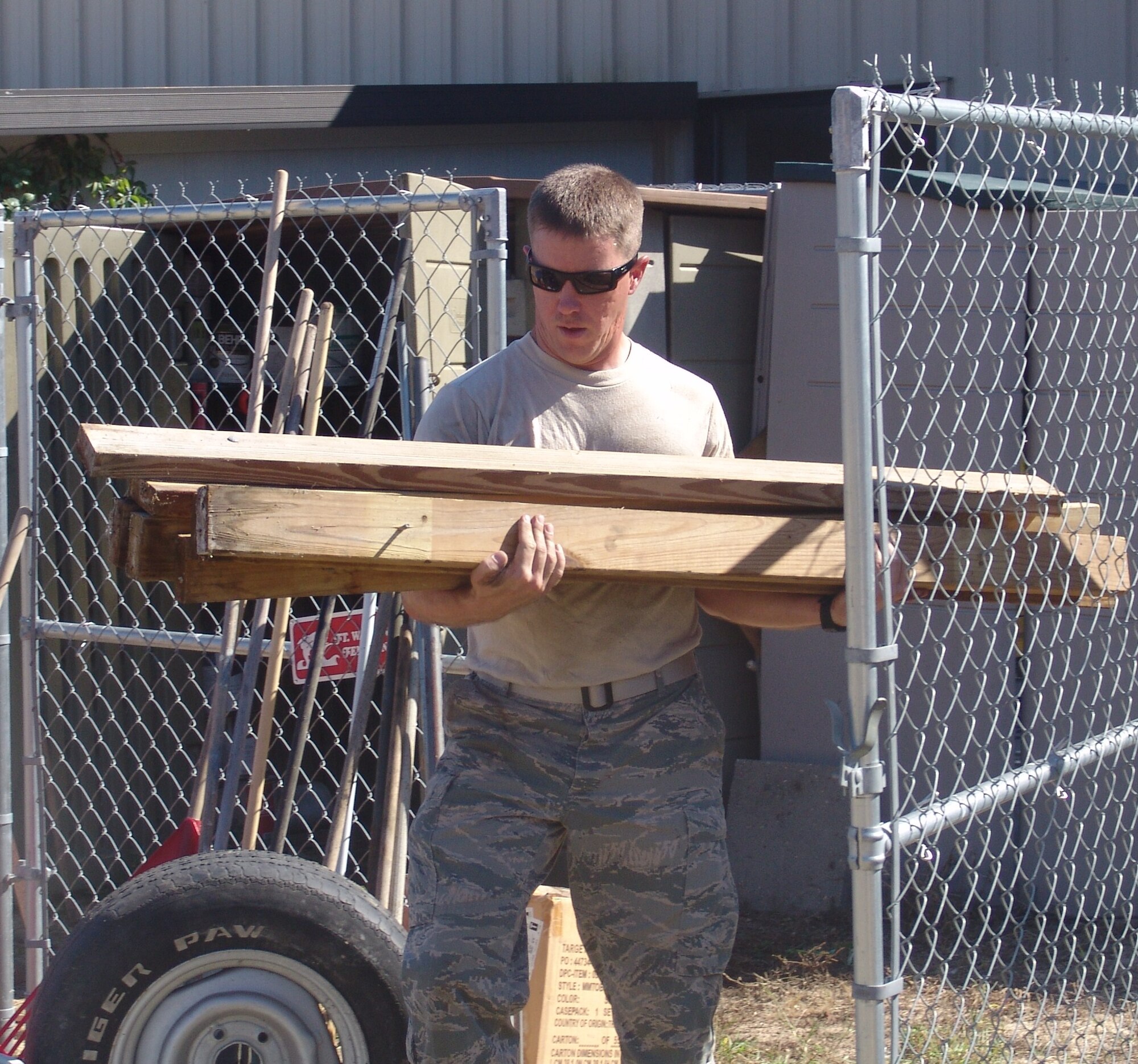 Airman 1st Class John Nelson removes lumber from a storage shed at the Boys and Girls Club.  Seven students from Naval School Explosive Ordnance Disposal spent their free day helping others. (USAF photo/Lois Walsh)