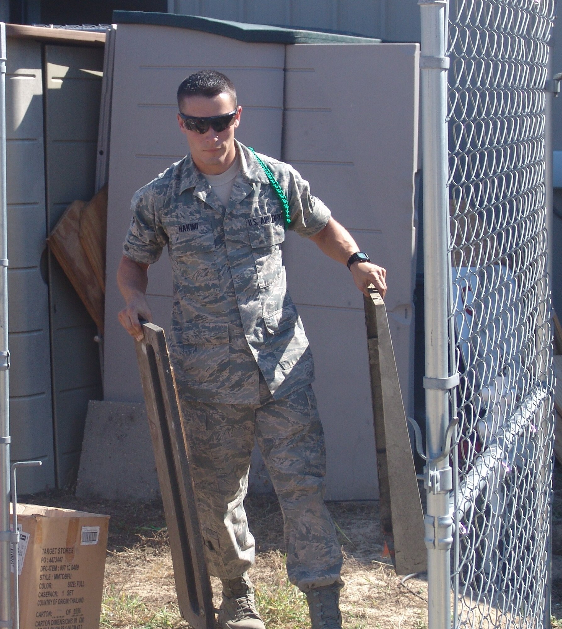 Airman 1st Class Shane Hakimi clears a storage shed at the Boys and Girls Club.  Seven students from Naval School Explosive Ordnance Disposal spent their free day helping others. (USAF photo/Lois Walsh)