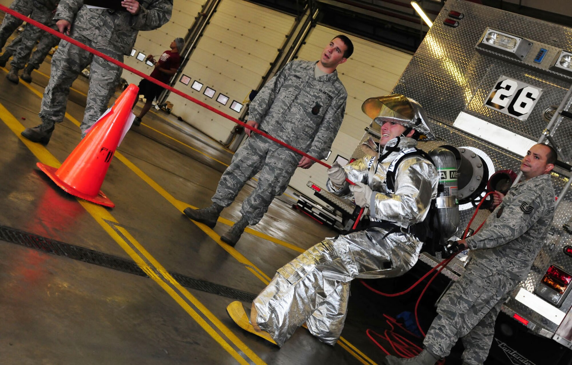 RAF MILDENHALL, England -- Staff Sgt. Nathanial Goodman, 100th Communications Squadron team member, pulls a rolled hose toward him during one of the events at the fire muster at the RAF Mildenhall Fire Department Oct. 13, 2011,. Five teams competed in the event, held as part of Fire Prevention Week. (U.S. Air Force photo/Karen Abeyasekere)