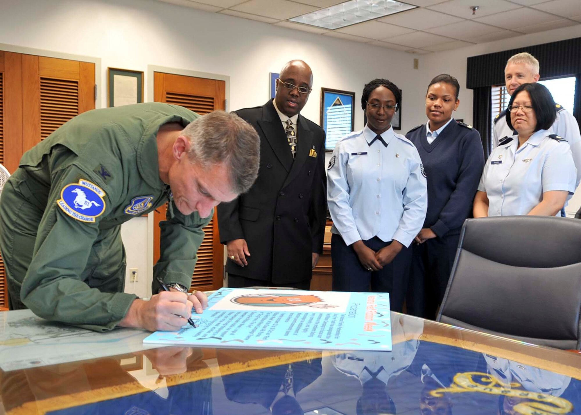 Col. Patrick McKenzie, 51st Fighter Wing commander, signs a proclamation for Red Ribbon Week Oct. 17, 2011. Red Ribbon Week raises awareness of drug use and the problems related to drugs facing the community. The program encourages Airmen, parents, educators and community members to promote drug-free lifestyles. This year's celebration will include activities on base for all age groups. (U.S. Air Force photo/Senior Airman Adam Grant)     