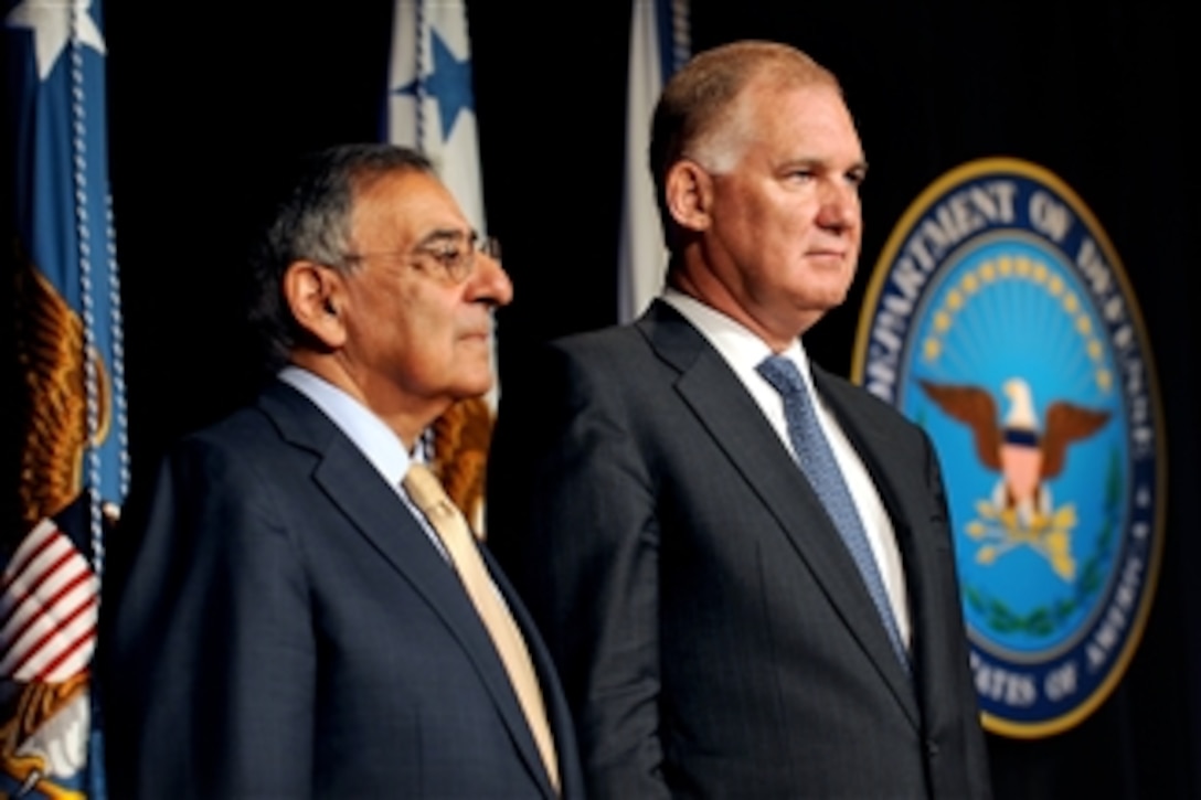 Secretary of Defense Leon E. Panetta, left, stands with former Deputy Secretary of Defense William J. Lynn III, as the citation is read for Lynn's award of the Department of Defense Medal for Distinguished Public Service at a farewell ceremony in honor of Lynn in the Pentagon, in Arlington, Va., on Oct. 13, 2011.  