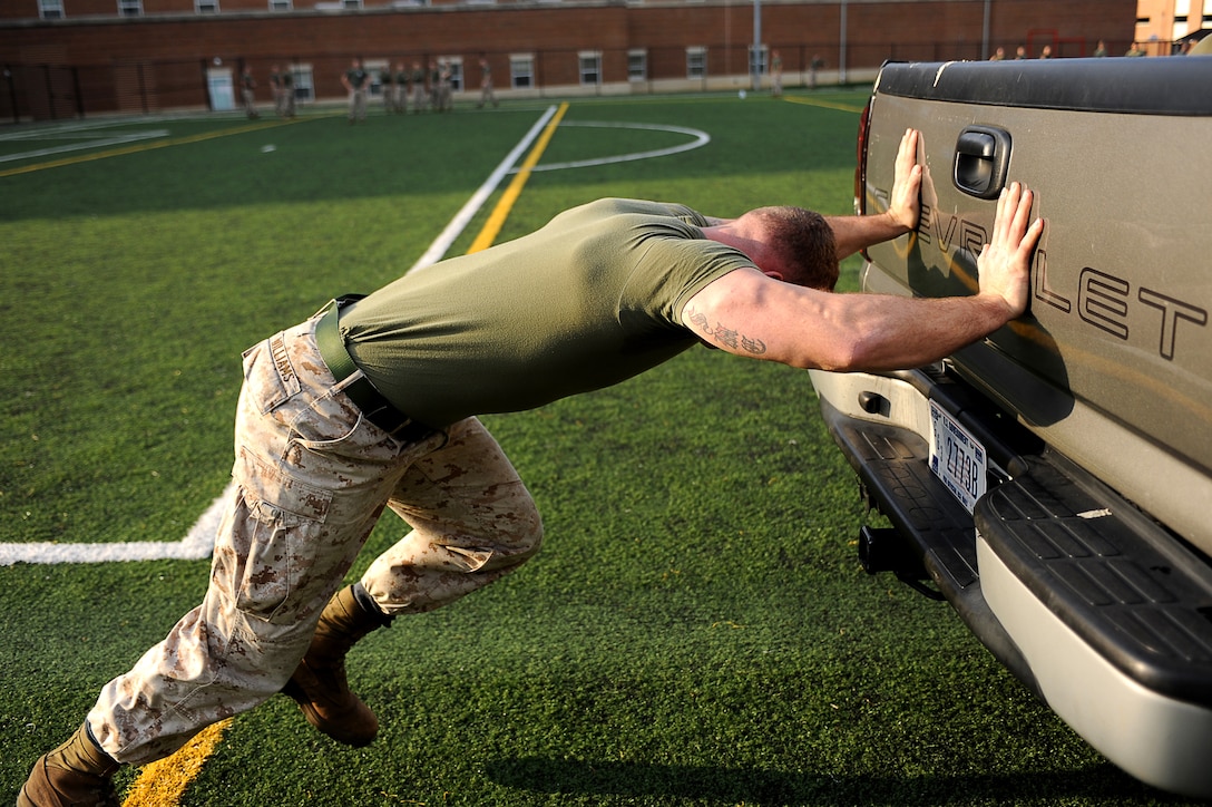 Cpl. Zachery Williams, a body bearer, pushes a 2.25-ton pickup truck 40 yards in the first timed event of Musclefest at Marine Barracks Washington Oct. 18, 2011. Musclefest was part of the Barracks' 2011 Commander's Cup series of competitions.