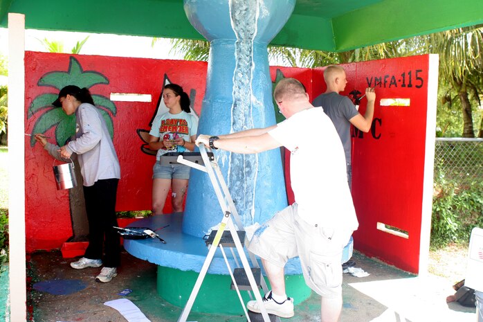 Marines and sailors from Marine Forces Pacific (Forward),Marine Aviation Logistics Squadron 12, Marine Fighter Attack Squadron 115 and Strike Fighter Squadron 94 paint together during  abeautification project here Oct. 19. Along with the beautification project, the Marines are also scheduled to interact with Junior Reserve Officer Training Corps cadets on Oct. 28 and Guam girl Power Day Saturday.