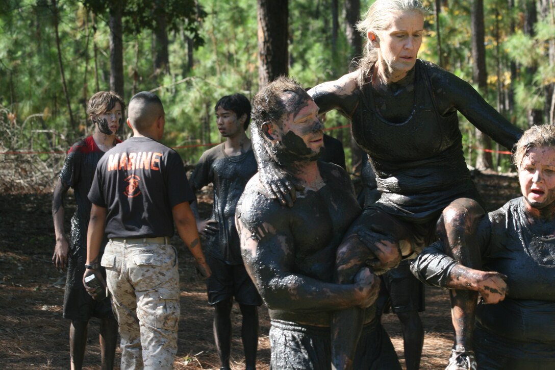 A team performs a modified fireman carry towards the end of the USMC Ultimate Challenge Mud Run course in Columbia, S.C., Oct. 15. Teams were made up of four participants each and include categories such as JROTC, Military, Homeland Heroes and Open Coed. (Official USMC photo by Cpl. Chris Kutlesa)