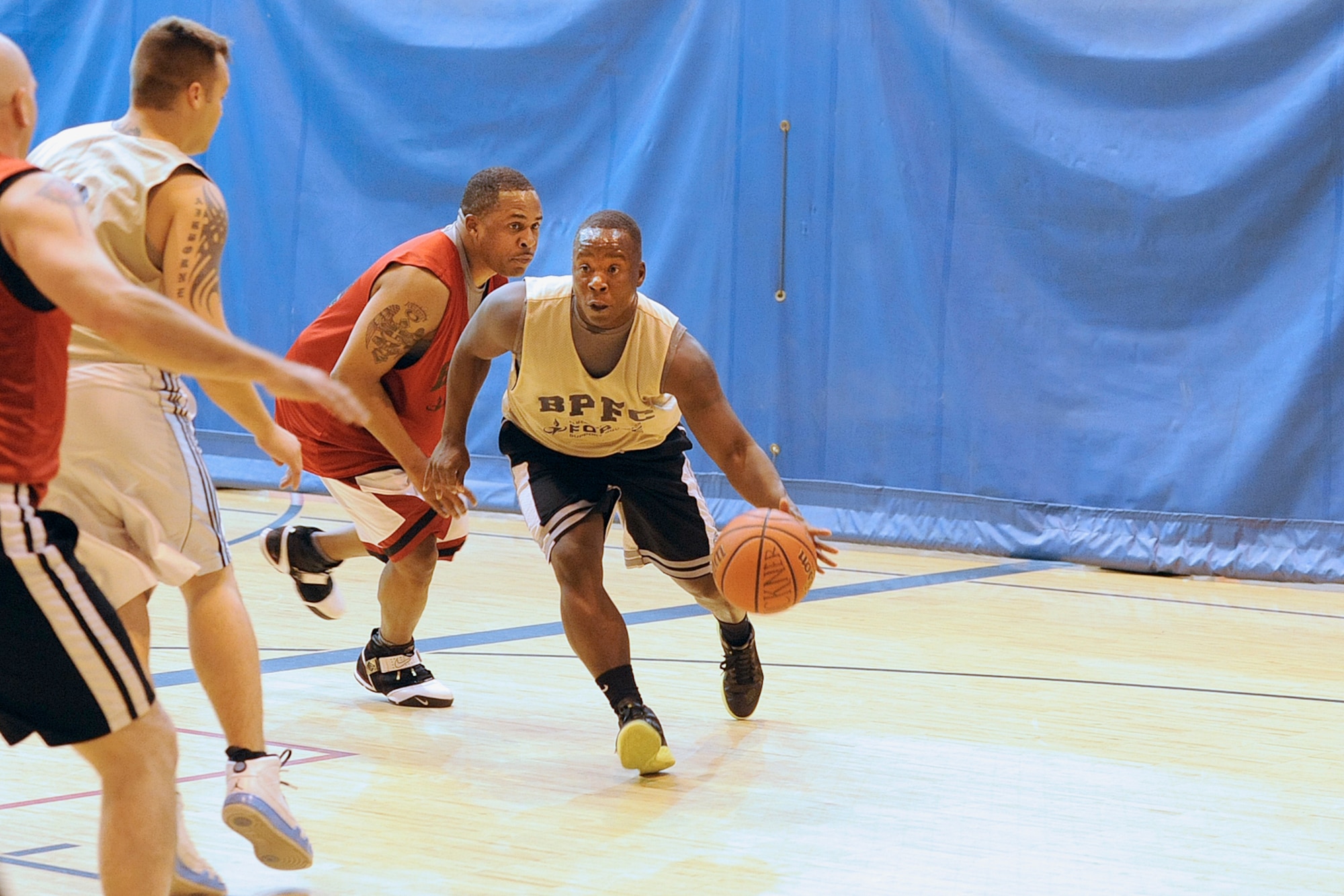 Intramural basketball action featuring 84th Engineer Support Company (gold jerseys) against Headquarters and Headquarters Company, 4th Brigade Combat Team (Airborne), 25th Infantry Division Oct. 17 at Buckner Physical Fitness Center. HHC/4-25th ABCT came from behind in the second half for a 48-43 victory. (U.S. Air Force photo/John Pennell)