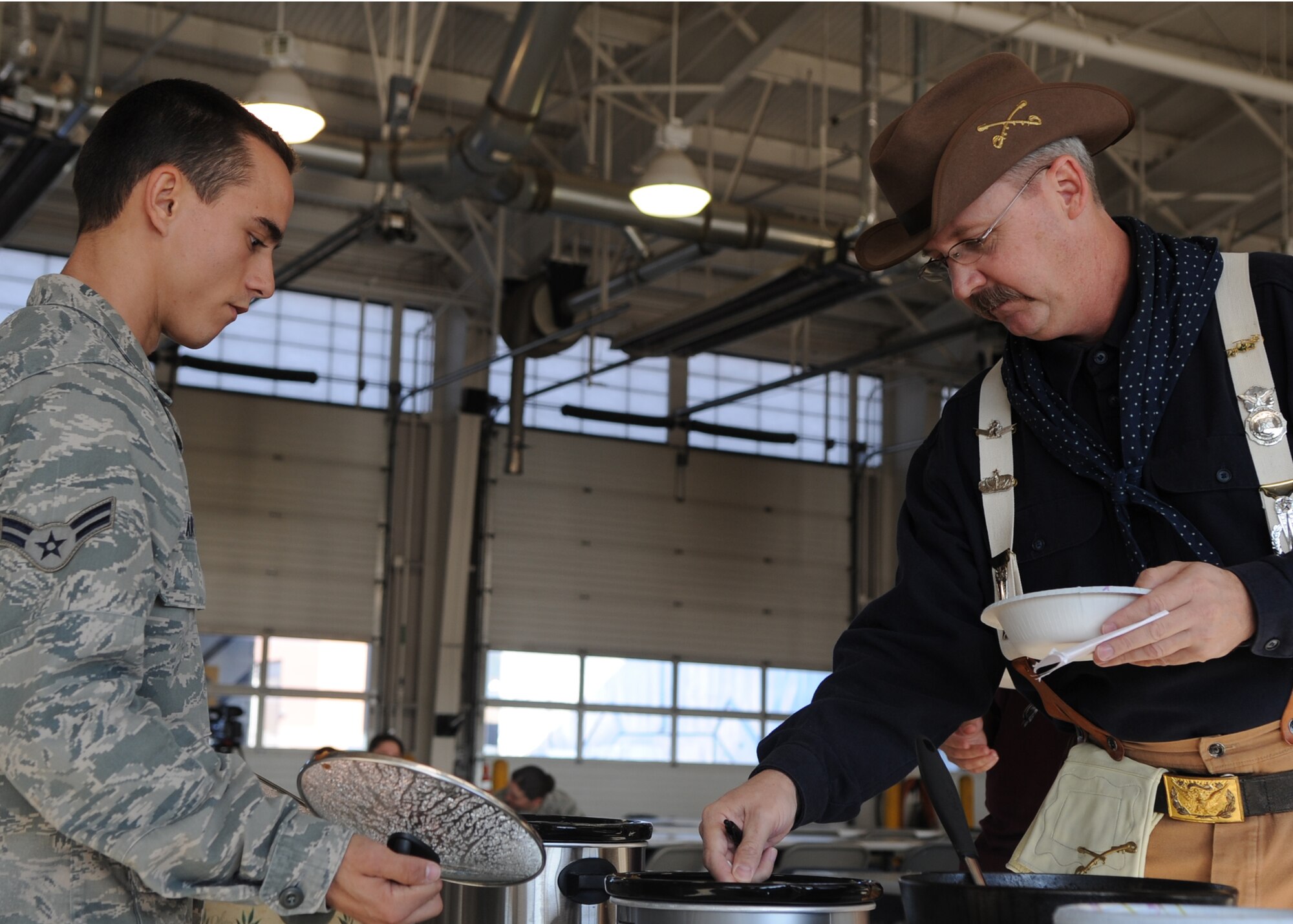 MINOT AIR FORCE BASE, N.D. -- Airman 1st Class Jonathan Artaud, 91st Missile Security Forces Squadron force response member, and retired U.S. Air Force Master Sgt. Dave Larrison, dressed as the wing's mascot Teddy Roosevelt, participate in the Global Strike Challenge Chili cook-off here, Oct. 19. 91st Security Forces Group team members were selected for the 2011 Air Force Global Strike Command Global Strike Challenge during their annual team rally. (U.S. Air Force Photo/Senior Airman Ashley N. Avecilla)

