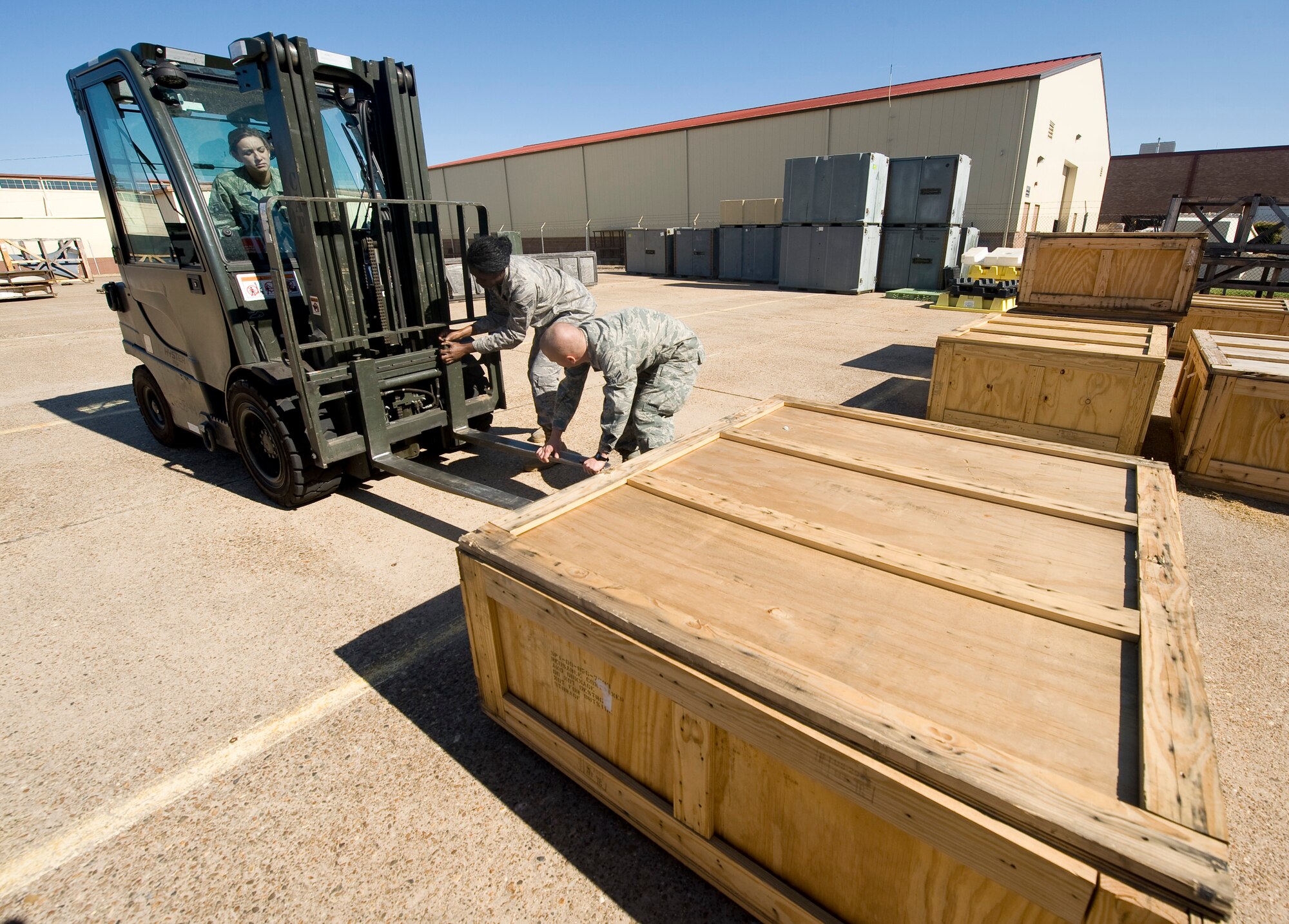 Airmen from the 2nd Logistics Readiness Squadron prepare a forklift before moving a pallet to the storage warehouse on Barksdale Air Force Base, La., Oct. 19. The 2 LRS provides supply and transportation support to various units on base. (U.S. Air Force photo/Senior Airman Chad Warren)(RELEASED)