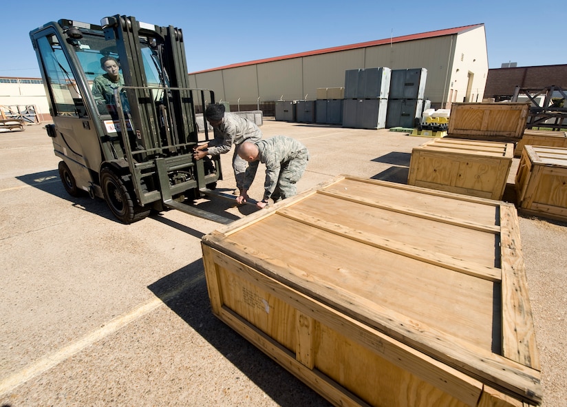 Airmen from the 2nd Logistics Readiness Squadron prepare a forklift before moving a pallet to the storage warehouse on Barksdale Air Force Base, La., Oct. 19. The 2 LRS provides supply and transportation support to various units on base. (U.S. Air Force photo/Senior Airman Chad Warren)(RELEASED)
