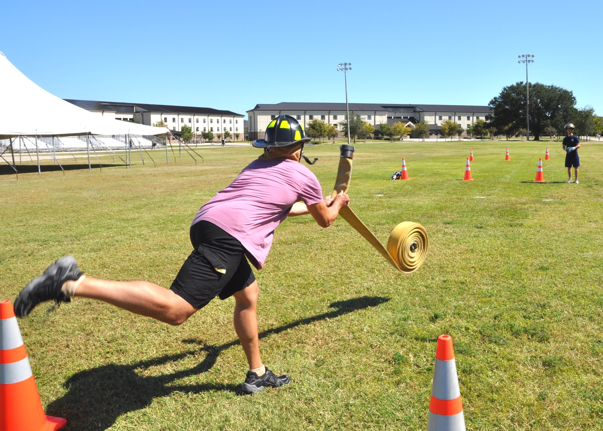 Airman 1st Class Aleksandar Petrakov, tosses a fire hose as Senior Airman Christopher Foster waits at the next leg of the “Firefighter Challenge” portion of the Oct. 14 Keesler Air Force Base, Miss., annual Fire Muster.  Both are members of the 81st Medical Operations Squadron “Dragon Medics” team.   The Fire Muster, sponsored by the Keesler Fire Department, was held in conjunction with Fire Prevention Week, Oct. 11-15, 2011.  (U.S. Air Force photo by Steve Pivnick)