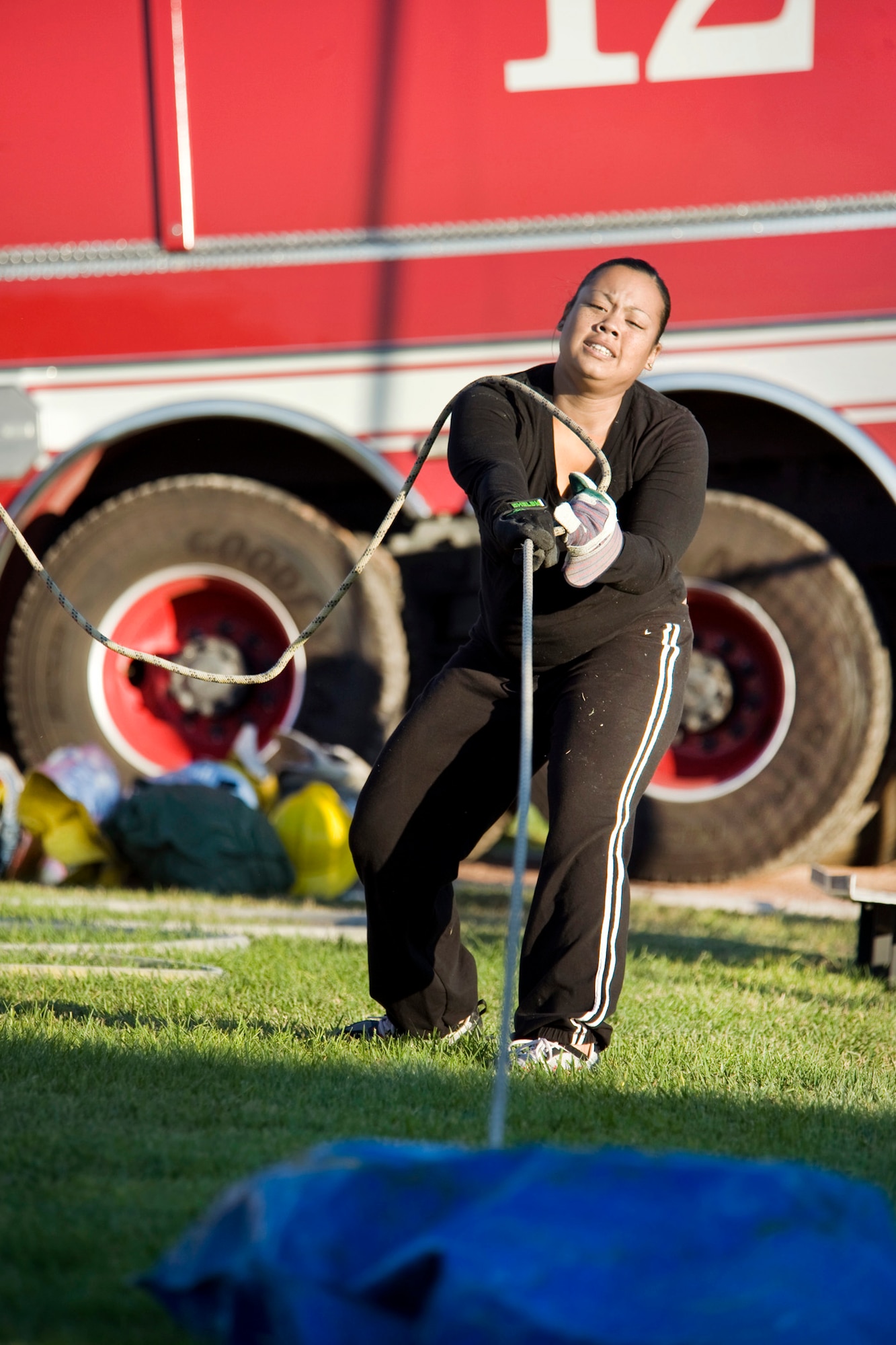 Staff Sgt. Stephanie Gunner, 57th Maintenance Squadron Test Measurement Diagnostic Equipment Flight quality process evaluator, strains to pull a 30-pound bean bag to the finish line the during the obstacle course portion of the fifth annual fire muster competition Oct. 14, 2011, at Freedom Park on Nellis Air Force Base, Nev.  (U.S. Air Force photo by Lawrence Crespo)
 