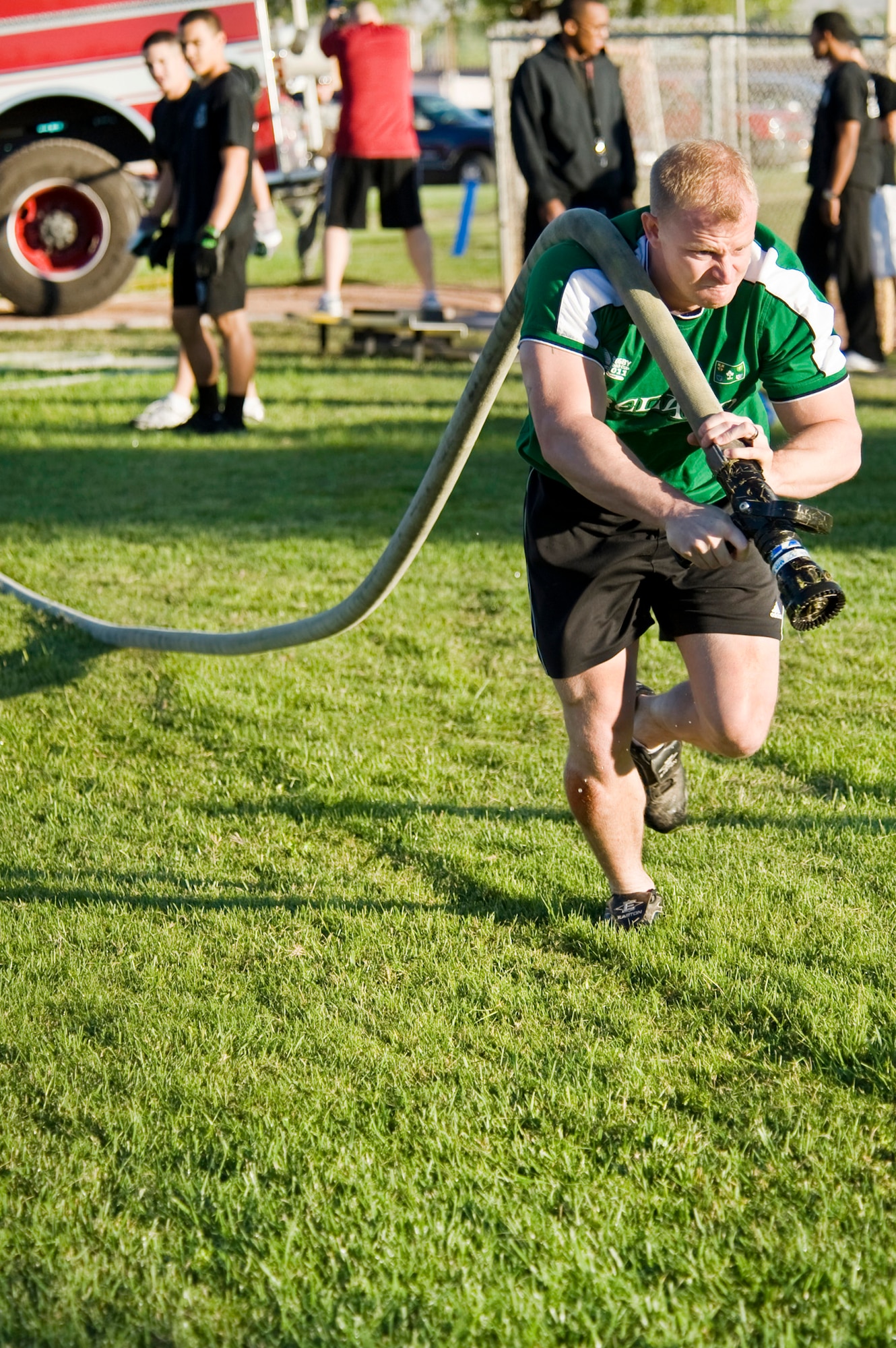 Staff Sgt. Paul Barber, 57th Maintenance Squadron Test Measurement Diagnostic Equipment Flight Safety NCO in charge, pushes himself as he pulls a fire hose to the finish line during an obstacle course at the fifth annual fire muster competition Oct. 14, 2011, at Freedom Park on Nellis Air Force Base, Nev. (U.S. Air Force photo by Lawrence Crespo)