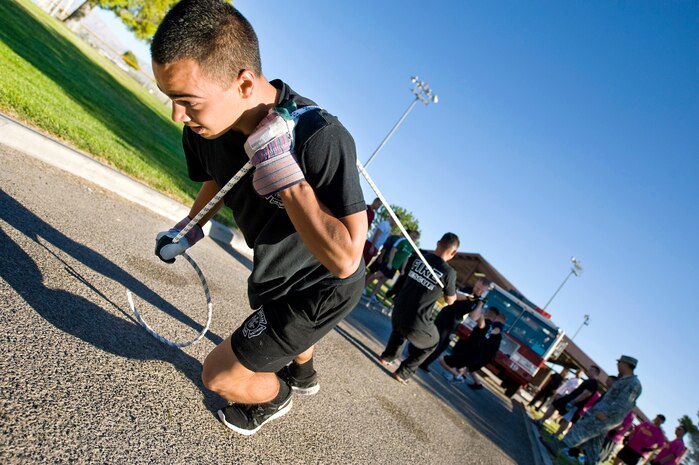 U.S. Air Force Airman 1st Class Gabriel Anderson, 99th Civil Engineer Squadron fire protection apprentice, and his team pull a P-19 Aircraft Rescue Firefighting vehicle during the fifth annual fire muster competition Oct. 14, 2011, at Freedom Park on Nellis Air Force Base, Nev. (U.S. Air Force photo by Lawrence Crespo)
 