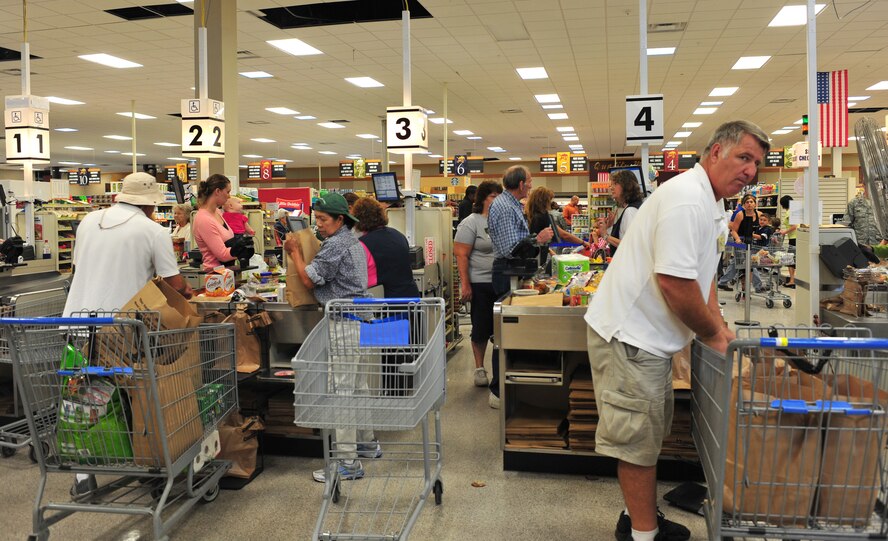 Commissary cashiers and baggers process shoppers through the checkout line during the reopening at Moody Air Force Base, Ga., Oct. 19, 2011. The commissary will be adding new registers and start utilizing new electric shelf labels within the next few months to help save money and man hours. All of the renovations, new equipment and labor were paid for by the surcharges applied during checkout. (U.S. Air Force photo by Staff Sgt. Stephanie Mancha/Released)