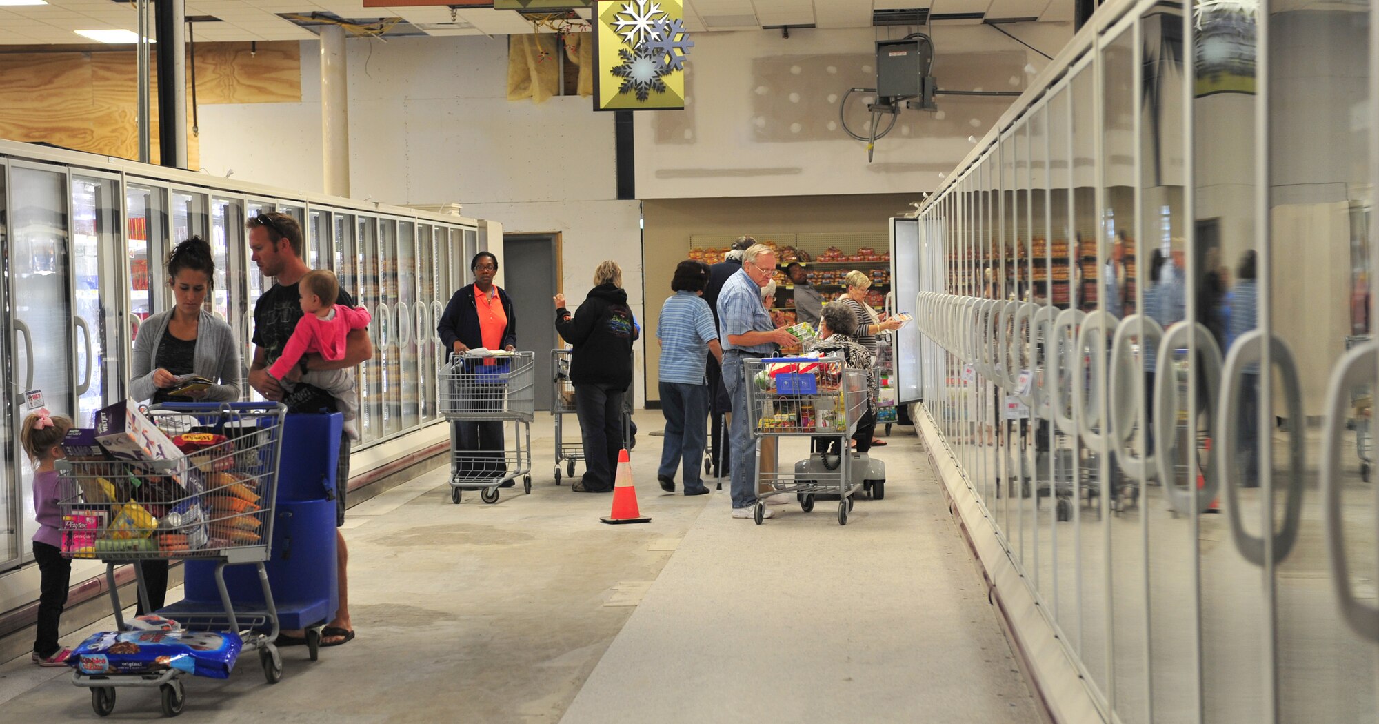Moody Air Force Base commissary customers shop from the new motion sensor freezers during the reopening of the commissary Oct. 19, 2011. In an effort to go green, the freezers have been equipped with motion sensor lighting. The commissary is taking many steps towards becoming energy efficient. (U.S. Air Force photo by Staff Sgt. Stephanie Mancha/Released)