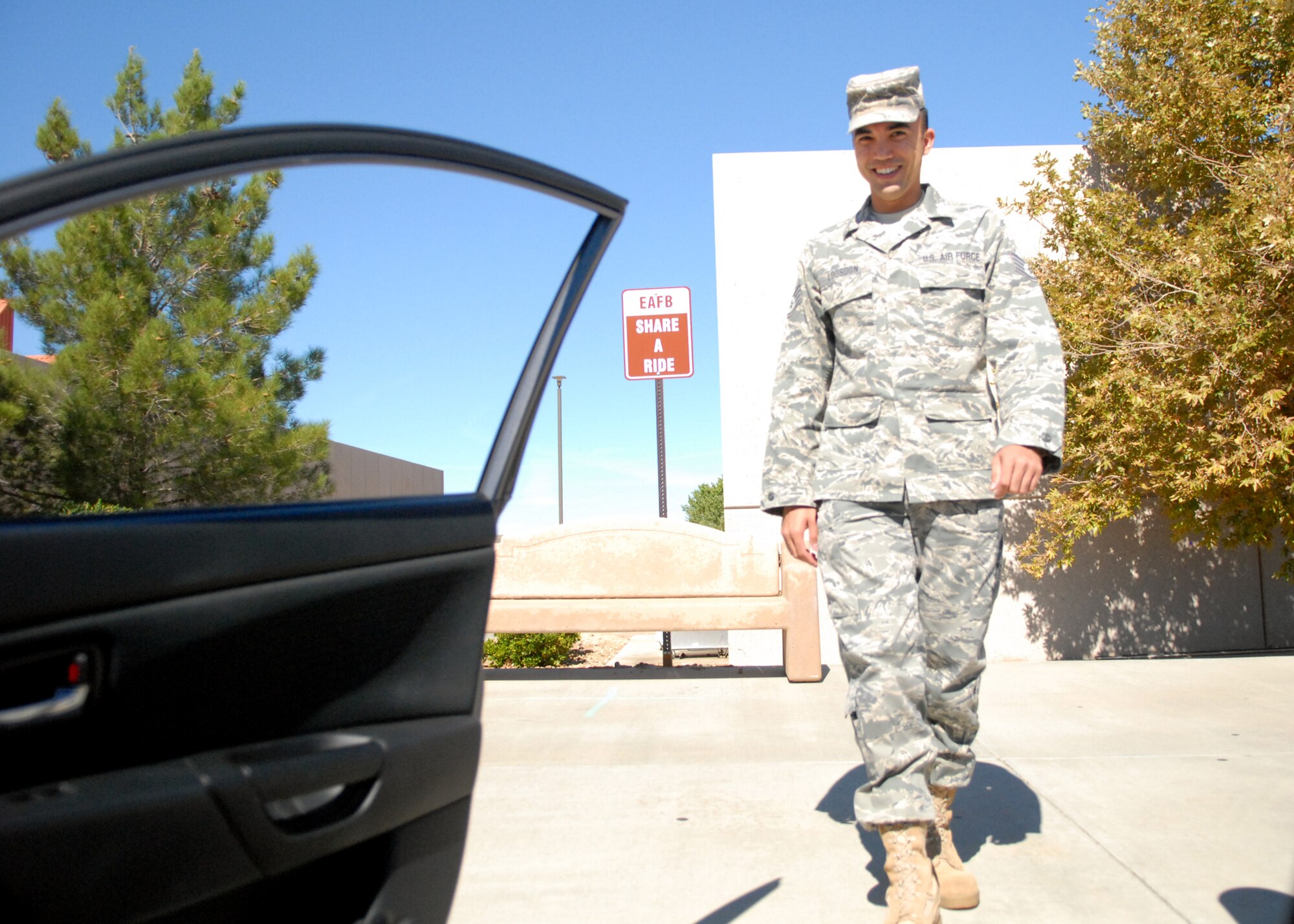Staff Sgt. Michael Logsdon, 95th Communications Squadron, looks to take advantage of the Edwards “Share a Ride” program outside of the Base Exchange, one of the five designated locations around base. The program is a new base initiative that provides a means for military personal without automobiles an avenue of transportation around the base. (Air Force photo by Kate Blais)