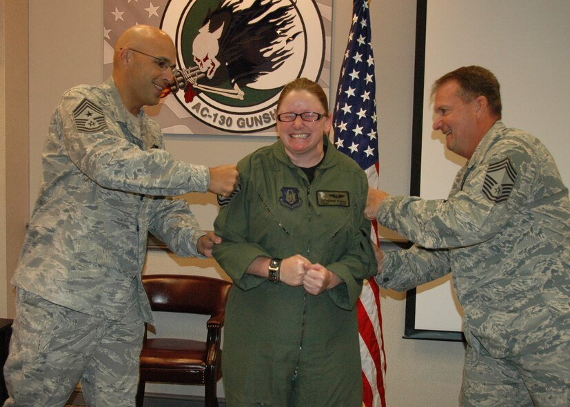 Newly promoted Tech. Sgt. Catherine Evers of the 711th Special Operations Squadron grimaces as Chief Master Sgts.  Michael Klausutis, the 919th Special Operations Wing Command Chief, and Tyler Outten of the 5th SOS, tack on her new enlisted stripes Oct. 1 at Duke Field, Fla.  Evers was one of six Duke Field reservists promoted under the Air Force Reserve’s Promotion Enhancement Program, designed to recognize exceptional performers for promotion to the grades of technical sergeant through chief master sergeant.  Two of the PEP promotees, Senior Master Sgt. Bruce Tims of the 919th Operations Support Squadron and Tech. Sgt. Nina Stubbs of the 5th Special Operations Squadron, were away on temporary duty assignments and unavailable for photos as the wing’s senior leaders traveled about the base to conduct the surprise promotion events.  (U.S. Air Force photo/Dan Neely)