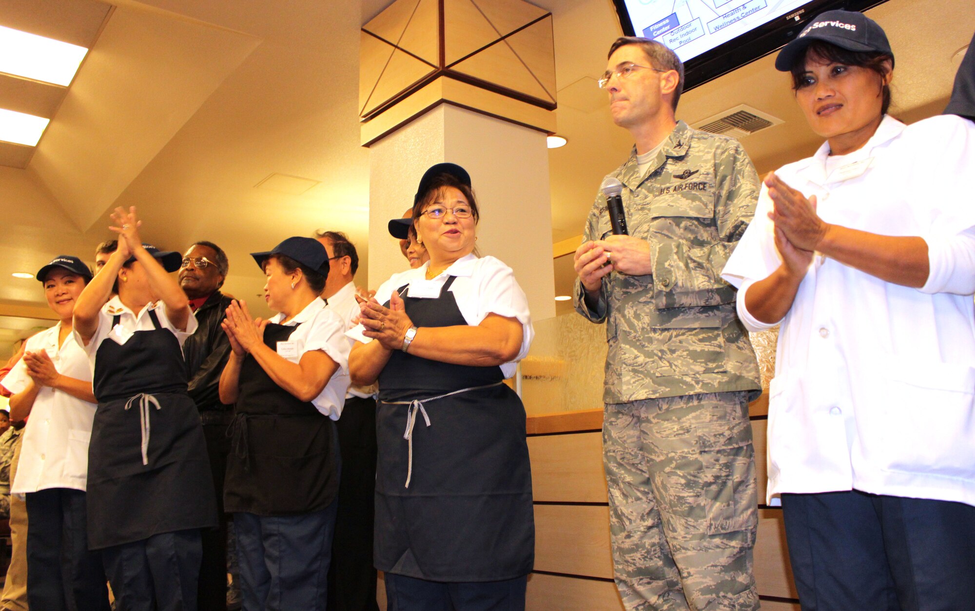 Crowds cheer as Col. Schwab annouces the reopened Joshua Tree Dining Facility will now be the latest addition to the Airman's Campus at Edwards. The Campus is a small footprint of support activities immediately adjacent to the dormitories.
 
"I want our Airmen and Marines to know these things are out here for them, said Schwab. "I don't ever want our members to think their only option is shutting themselves  their dorm rooms." 

The commander truly hopes unaccompanied military members will make use of the campus and find activities they enjoy sharing with teammates. (U.S. Air Force Photo by Meredith Mingledorff) 