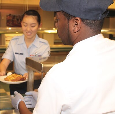 Airman 1st Class Shujie Yan, medical technician, 95th Medical Operations Squadron, is happy to receive a nice hot breakfast early Monday morning at the reopened Joshua Tree Dining Facility Oct. 17. (U.S. Air Force Photo by Meredith Mingledorff)