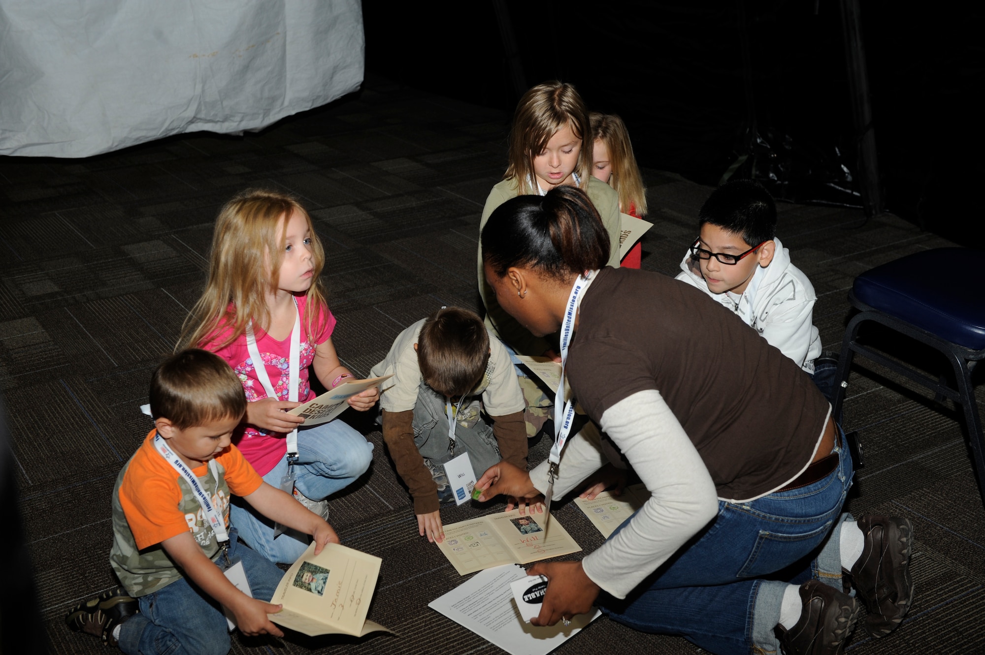 Children receive a passport stamp from Tech. Sgt. Sherita Outsey, 366th Operational Support Squadron, during Camp Desert Kids at Mountain Home Air Force Base, Idaho, Oct. 15, 2011. The children were taught common Afghanistan courtesies including not showing the soles of their feet to others, shaking and eating with their right hand only and allowing their elders to be on their left as a sign of respect. (U.S. Air Force photo by Senior Airman Angelina Drake)