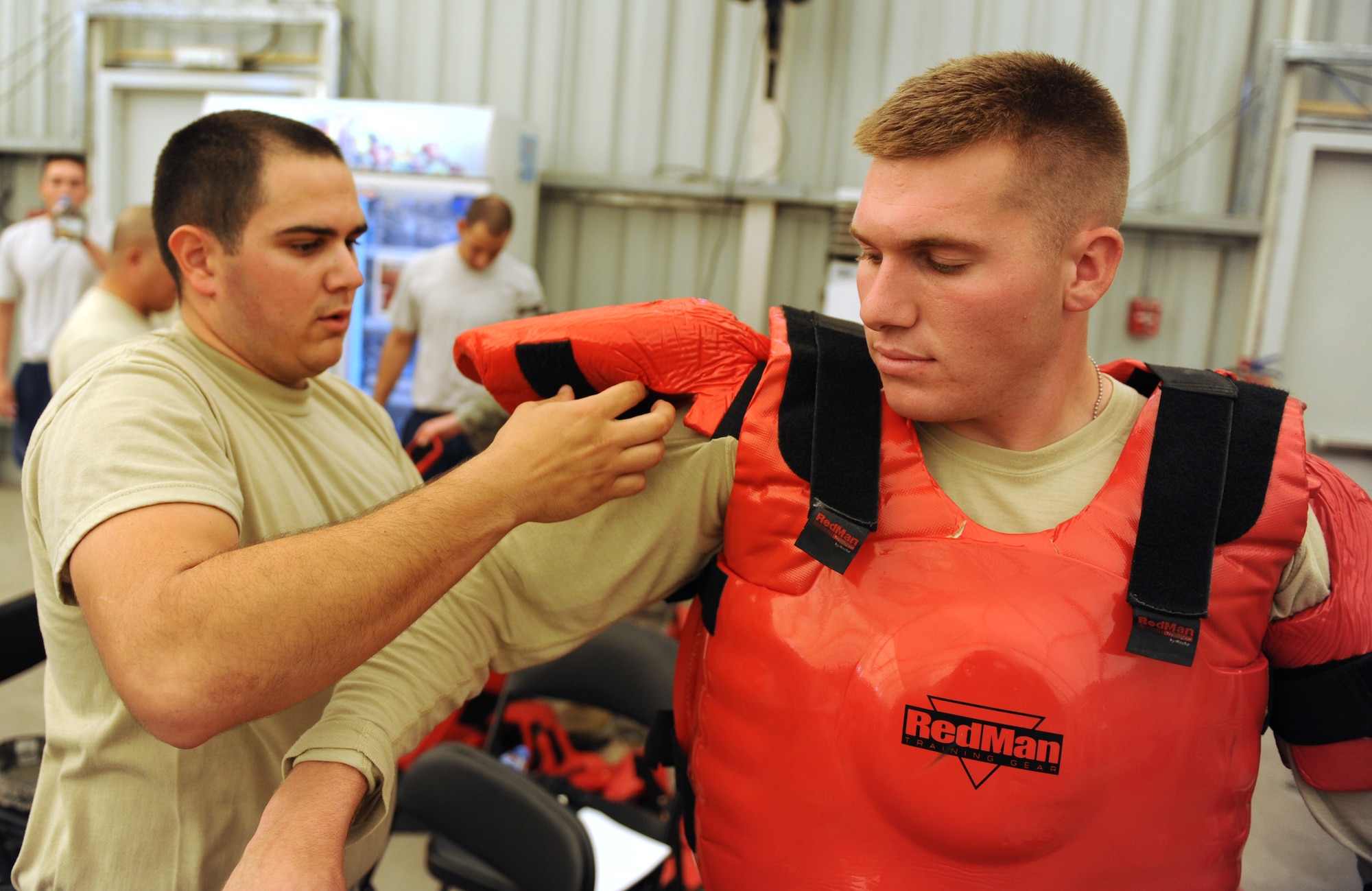 Senior Airman Troy Mace, an instructor for the training section of the 380th Expeditionary Security Forces Squadron, and a native of Florence, Ky., gets suited up in the RedMan Training Gear Oct. 15, 2011, at the 380th Air Expeditionary Wing in Southwest Asia. The training, which is known as the ?red man practical,? consists of less-than lethal tactics used to gain compliance from a subject who is demonstrating the intent to cause serious bodily harm to oneself or others. (U.S. Air Force photo/Master Sgt. Chance Babin)