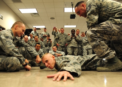 628th Security Forces members watch a volunteer being tased during annual Use of Force/Taser training at Joint Base Charleston Oct. 18. The taser is a technique security forces members can use during the escalation of necessary use of force requirements. (U.S. Air Force photo/Staff Sgt. Katie Gieratz)