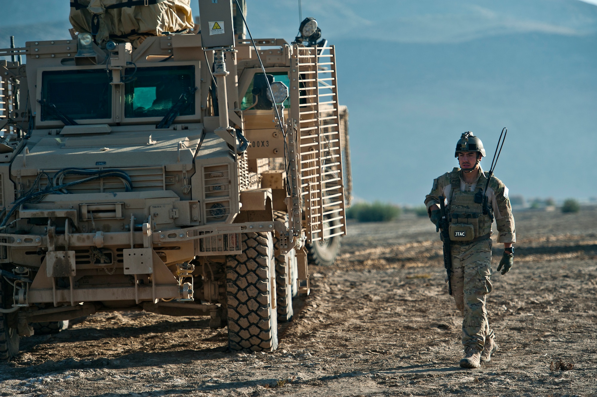 U.S. Air Force Joint Terminal Attack Controller, Senior Airman Cristobal Galindo, 807th Expeditionary Air Support Squadron, and native of San Bernardino, Calif., walks past a mine-resistant ambush-protected vehicle on Oct. 13, 2011. Galindo is a about to go on a foot patrol with members of U.S. Army Alpha Troop, 2nd Squad, 38th Calvary, Ft. Hood, Texas, to clear an area suspected to have insurgent activity and, if necessary, direct combat aircraft providing close air support.  (U.S. Air Force Photo/Master Sgt. Jeffrey Allen)