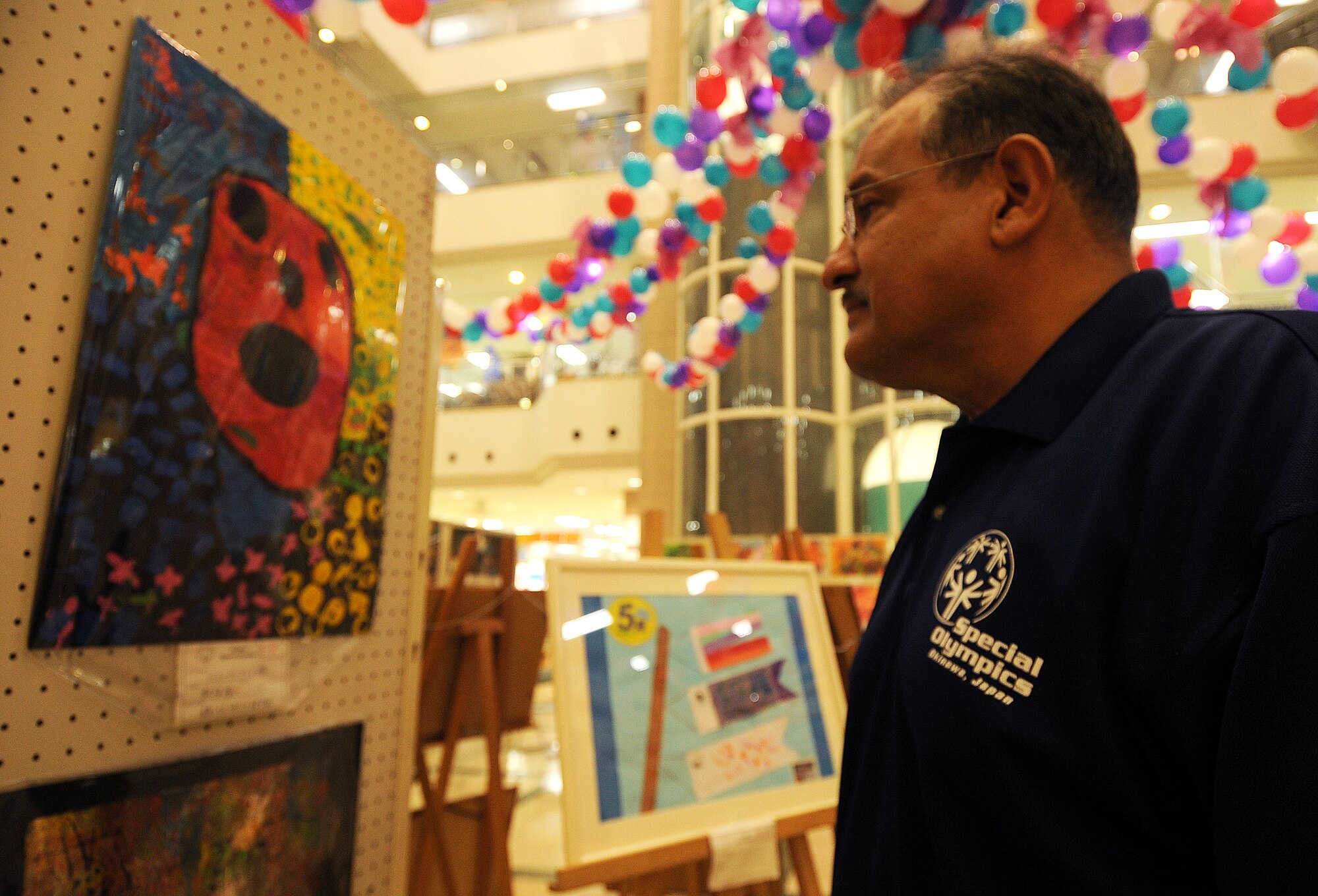 Felipe Jimenez, 18th Mission Support Group deputy director, looks over Kadena Special Olympics art exhibits on display at Main City Shopping Mall in Uruma City Oct. 13. Artwork from more than 430 Okinawan and U.S. artist was on display. The 12th Annual KSO games are scheduled for Nov. 5. Organizers are looking for nearly 1,000 volunteers for the event. Visit www.kadenaspecialolympics.com to volunteer or get more information. (U.S. Air Force/Tech. Sgt. Jason Lake)
