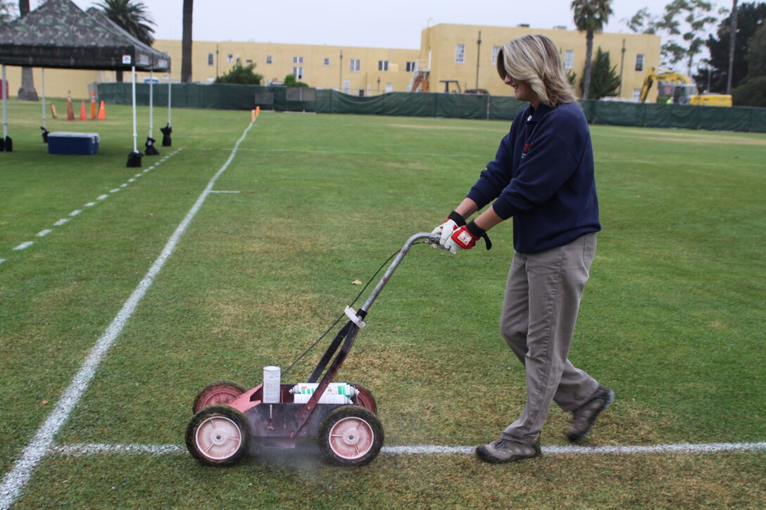 Rachel Dickinson, Marine Corps Community Services, intramural sports coordinator, paints lines on the football field before Powder Puff game Oct. 19 on Marine Corps Recruit Depot San Diego. Dickinson organizes everything from leagues to one-day tournaments for Department of Defense personnel aboard the depot. "I'm part of the pre-event and then I get to see everything unfold," said Dickinson. For the past 12 years she has been going the extra mile to accommodate to depot personnel intramural sports needs and will continue doing so. "Its hard to move on from something you love," said Dickinson.
