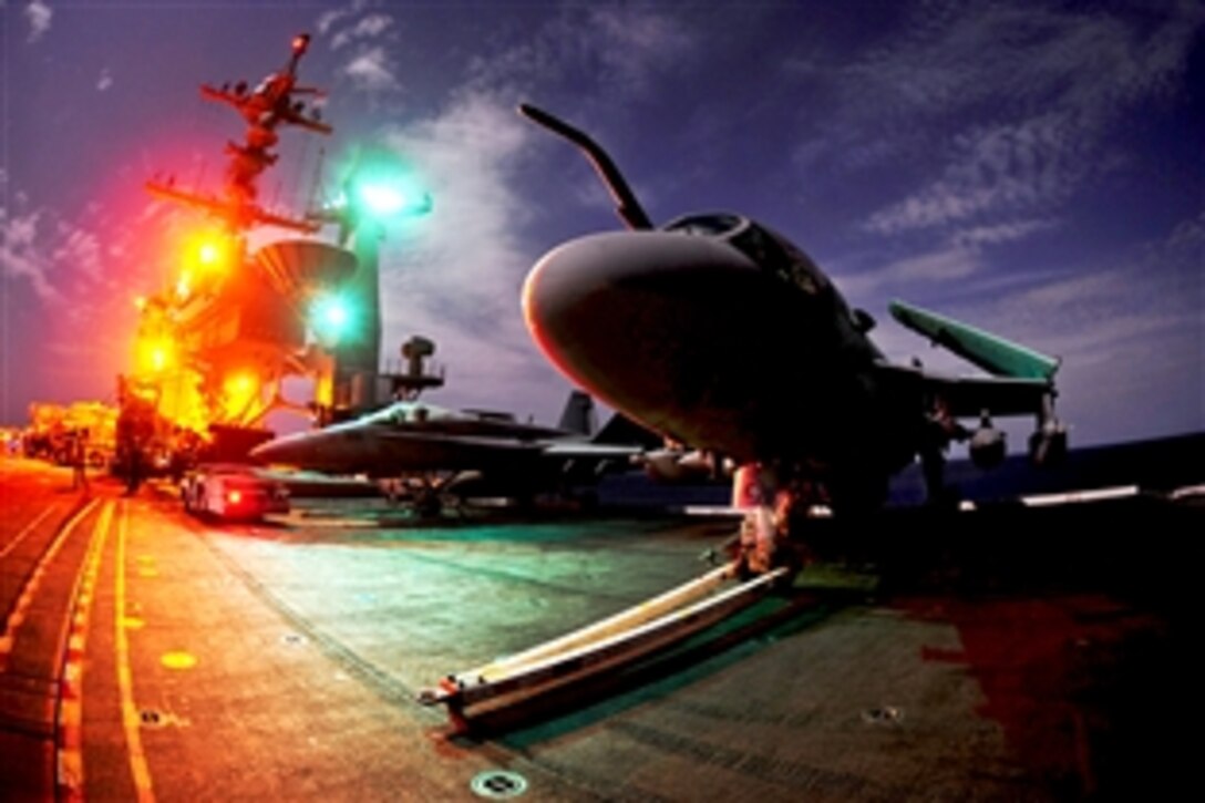 A U.S. Navy EA-6B Prowler aircraft sits on the flight deck while sailors prepare for an arrested landing aboard the USS John C. Stennis in the Arabian Sea, Oct. 11, 2011. The John C. Stennis is deployed to the U.S. 5th Fleet area of responsibility conducting maritime security operations and support missions as part of operations Enduring Freedom and New Dawn.