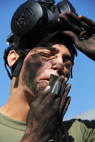 Lance Cpl. Dragos Carstea, a Marine All-Weather Fighter Attack Squadron 242 flight equipment technician, dabs his face with M90 powder during a monitor and survey decontamination course at the chemical biological radiological nuclear defense facility here Oct. 26. Marine Aviation Logistics Squadron 12 and VMF (AW)-242 Marines participated in the three-day course that trained service members in basics of monitoring and decontaminating a CBRN-contaminated area.„