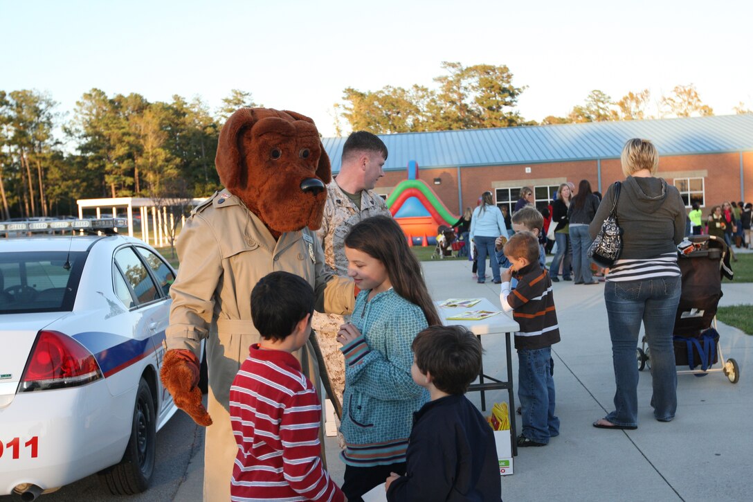 McGruff the Crime Dog talks with students while they take a break from the fall festivities at Johnson Primary School's annual celebration aboard Marine Corps Base Camp Lejeune, Oct. 20.